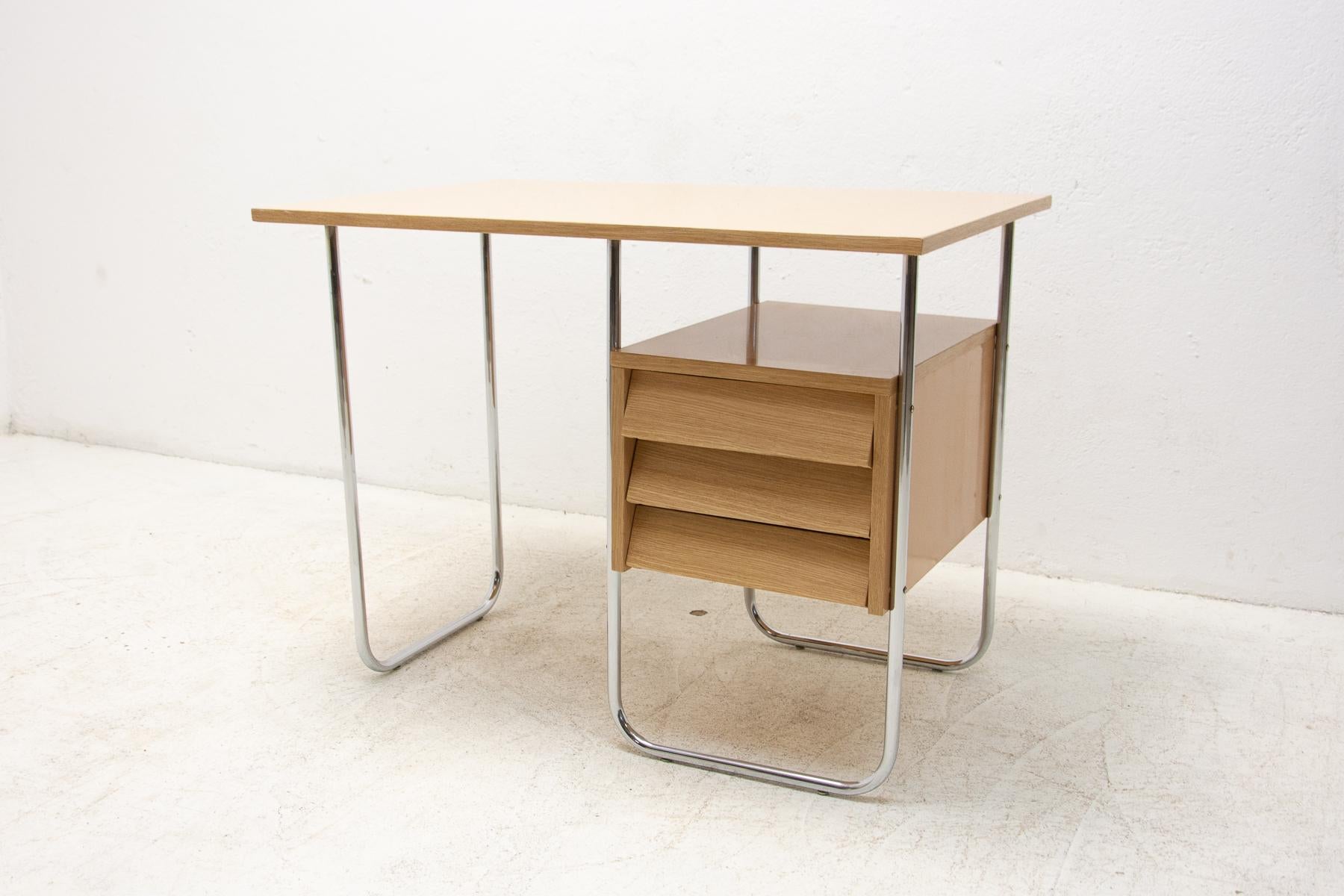 Midcentury writing desk with three plastic drawer. It has a construction of chrome pipes and a formica plate.

Very simple design, typical for the period of the 1930s–1950s in the former Czechoslovakia.

In very good vintage condition, shows