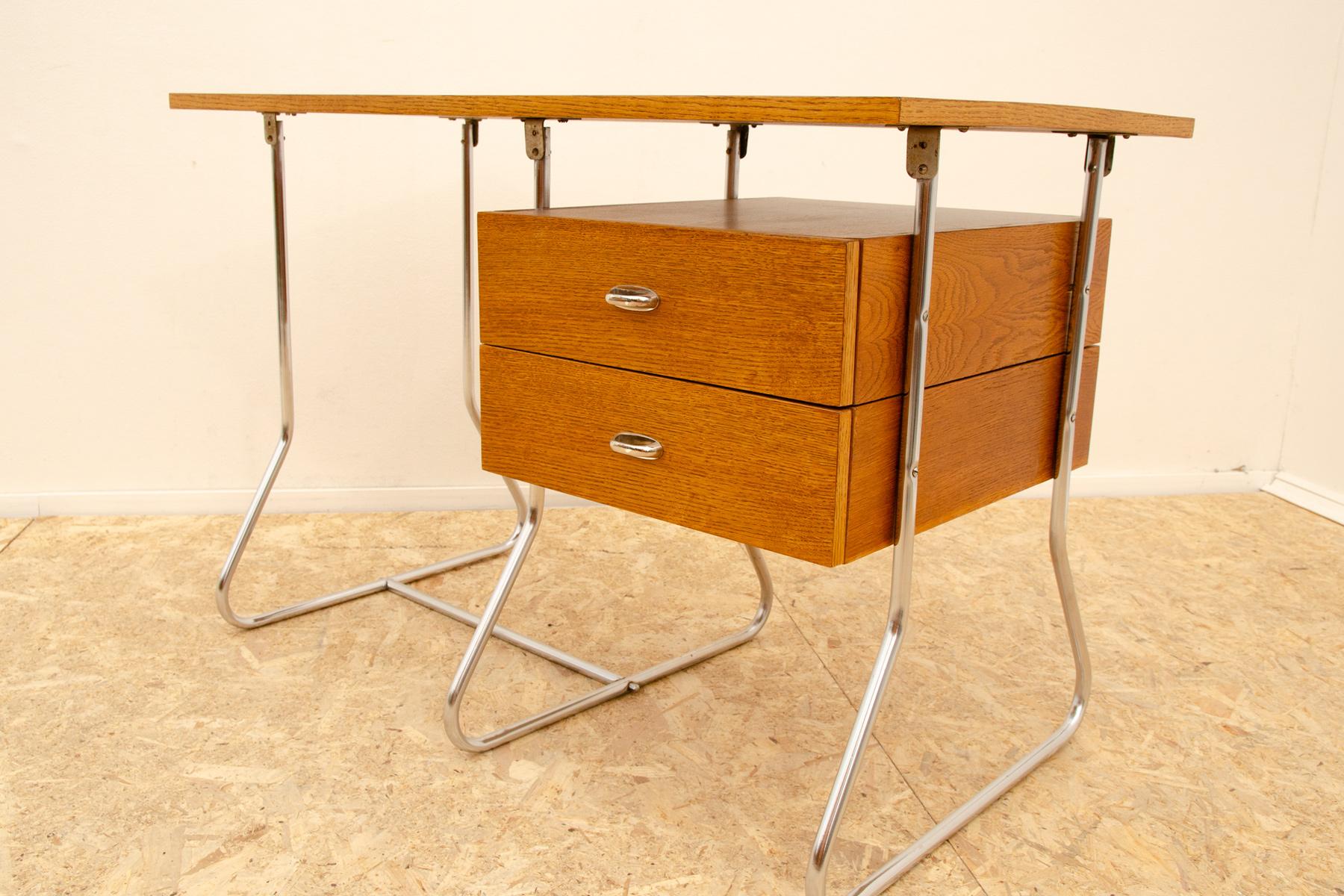 Escritorio funcionalista de mediados de siglo en estilo Bauhaus. Tiene estructura cromada, tablero de madera y cajones. Tiene una construcción de tubos cromados, placa de madera y tres cajones con tiradores cromados.

Diseño muy sencillo, típico de