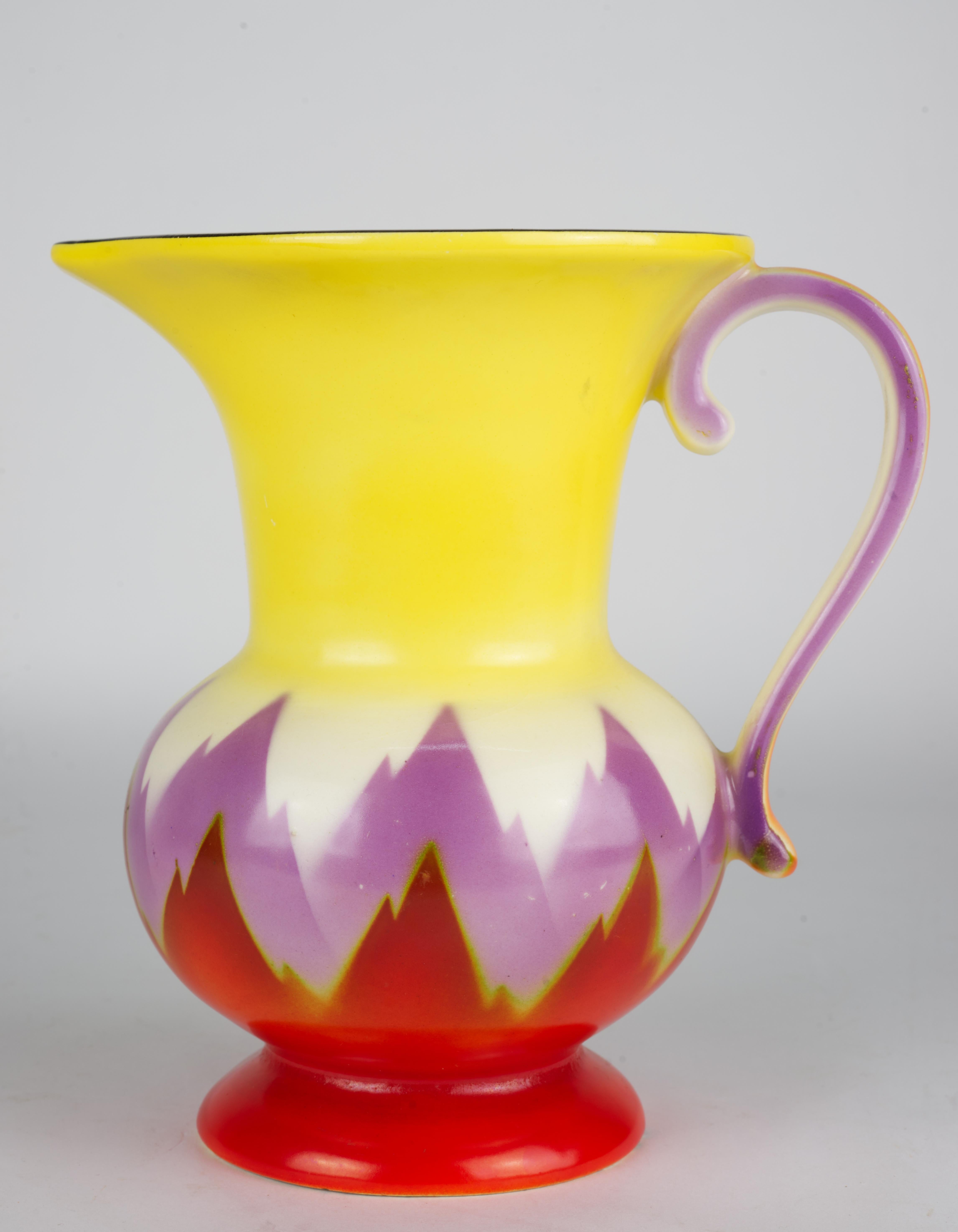  Art Deco pitcher with abstract flame design in hues of red, purple and yellow was made by Ditmar-Urbach Porcelain Factory. Urbach pottery was founded in 1882 in Turn-Teplitz, Bohemia (now Trnovany, Czech Republic) in 1882. It merged with Rudolf