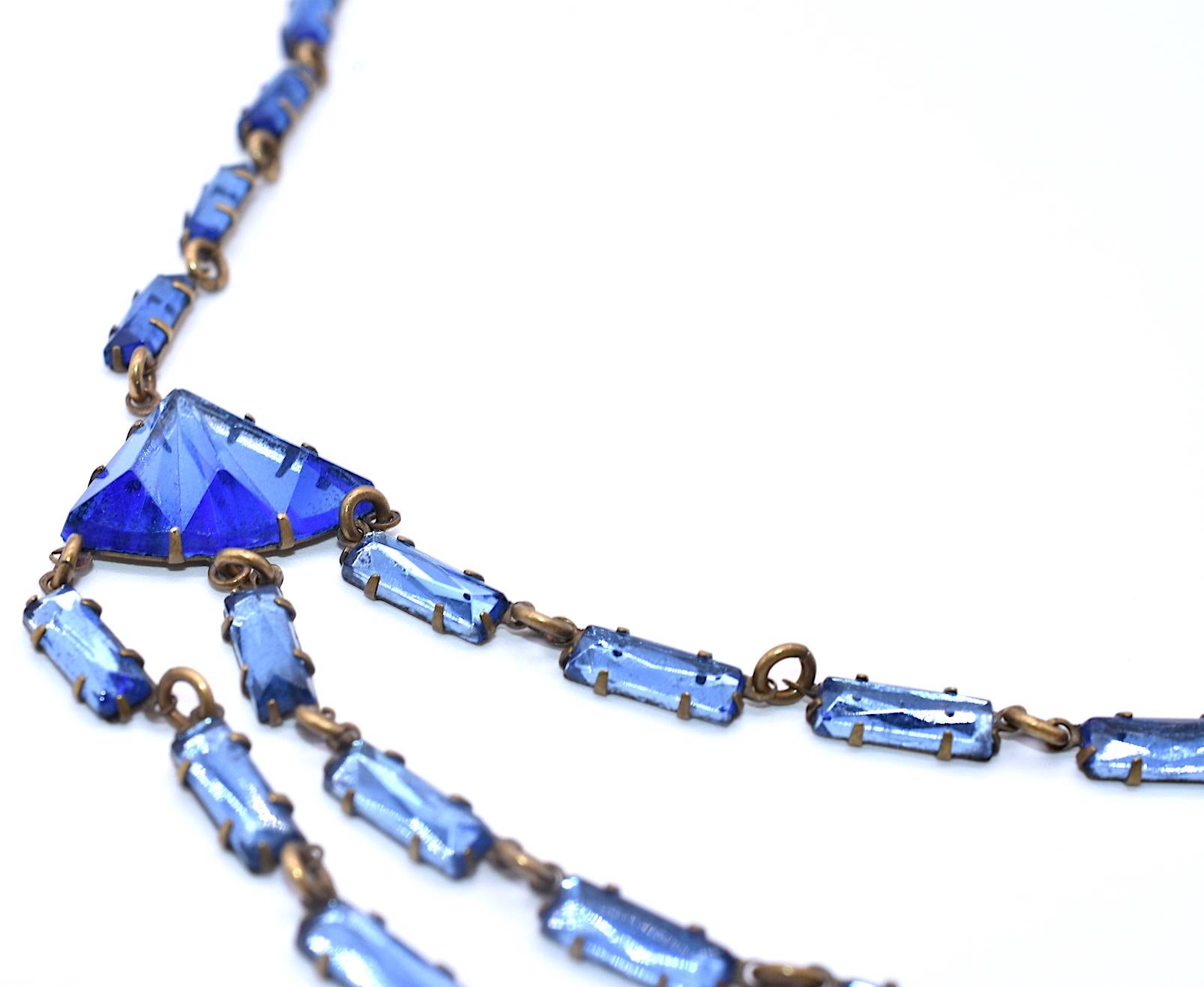 Considered vintage Czech costume jewelry, our Czechoslovakian glass necklace has beautifully carved cool blue mirror backed stones in classic Deco forms. The mirror-backed glass is of excellent quality and consistent color throughout. Mirror glass