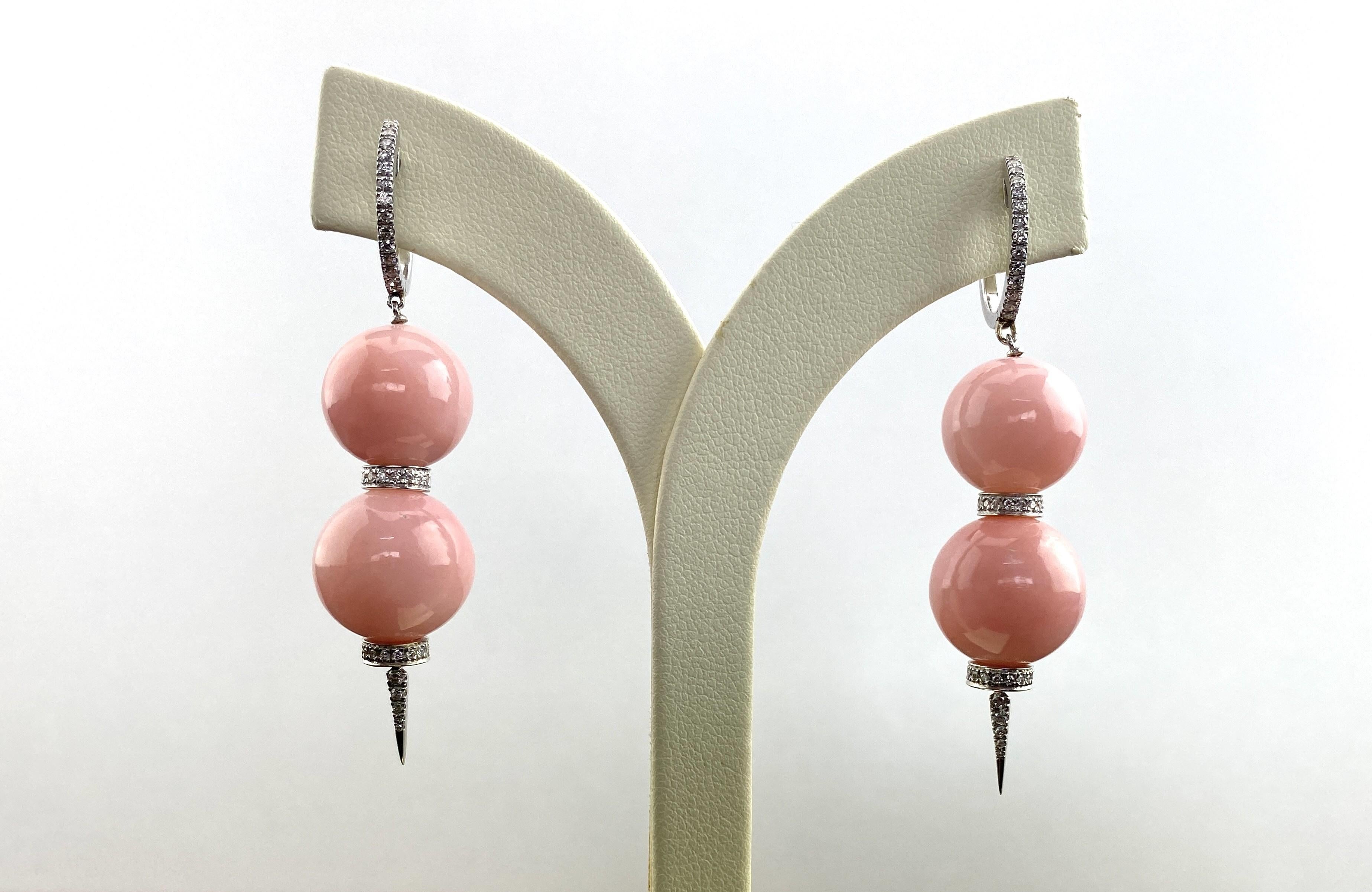 Perfectly blending the soft, romantic hue of pink opal with the dazzling brilliance of diamonds, these earrings are a must-have for anyone who appreciates unique and stylish jewelry.

Each earring features two round pink opal beads, with a total