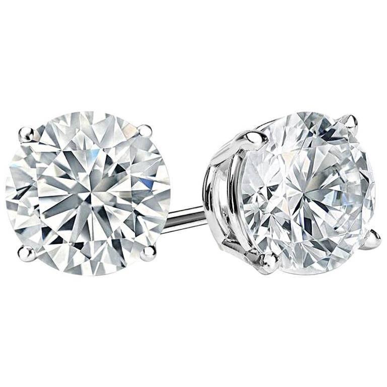 Excellent unique cut faux diamond 12 carats each stud set in rhodium sterling silver. These are the finest modern cut round fake cubic zirconia diamonds—half an inch in diameter. The whole authentic diamond look carat weight look would be 24 carats.