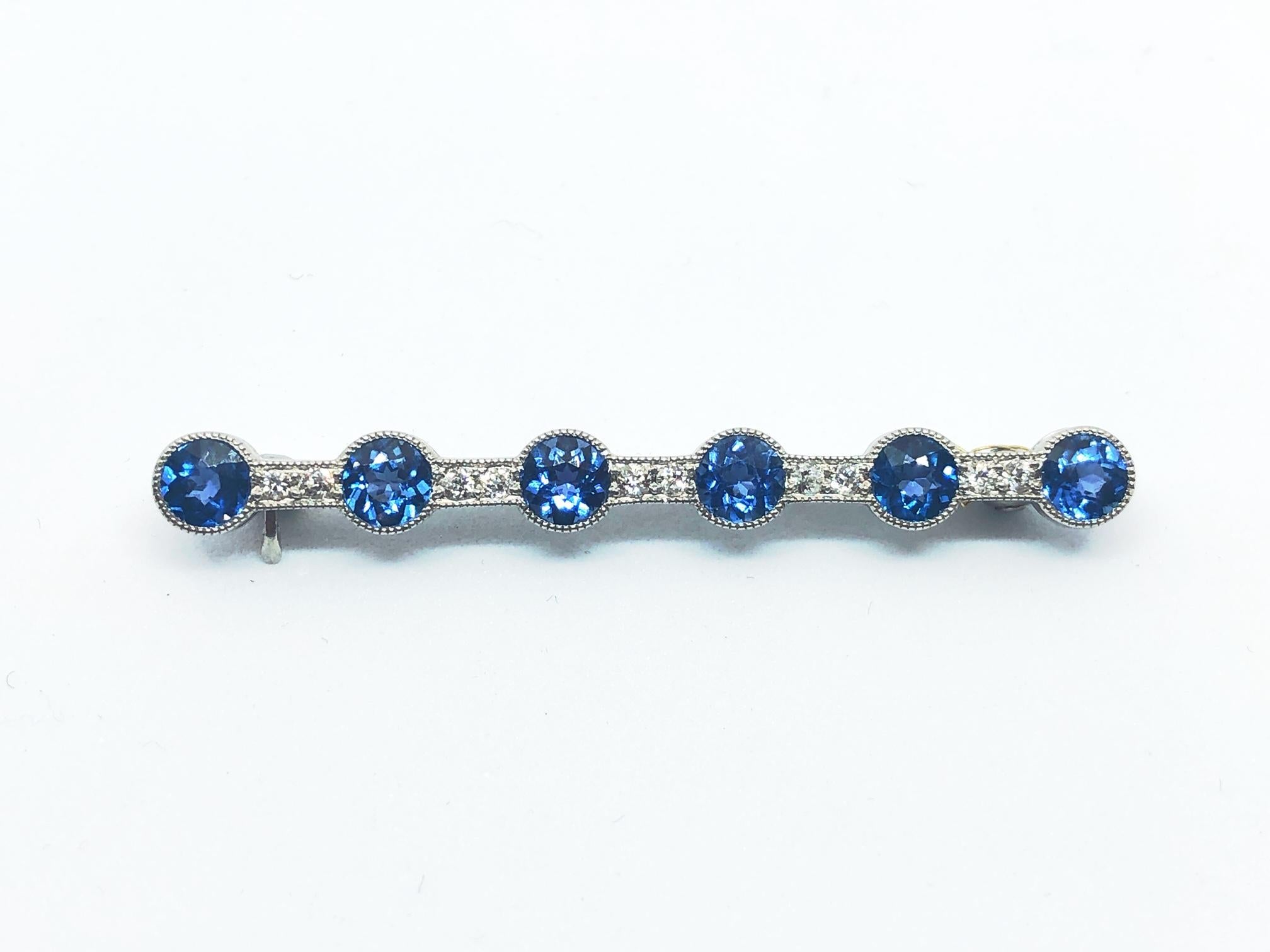 An Edwardian, Montana sapphire and diamond bar brooch, by D. D. Brokaw & Son, set with six round faceted Montana sapphires, with a total weight of approximately 2.70ct and ten old-cut diamonds, weighing approximately 0.26ct, mounted in platinum,