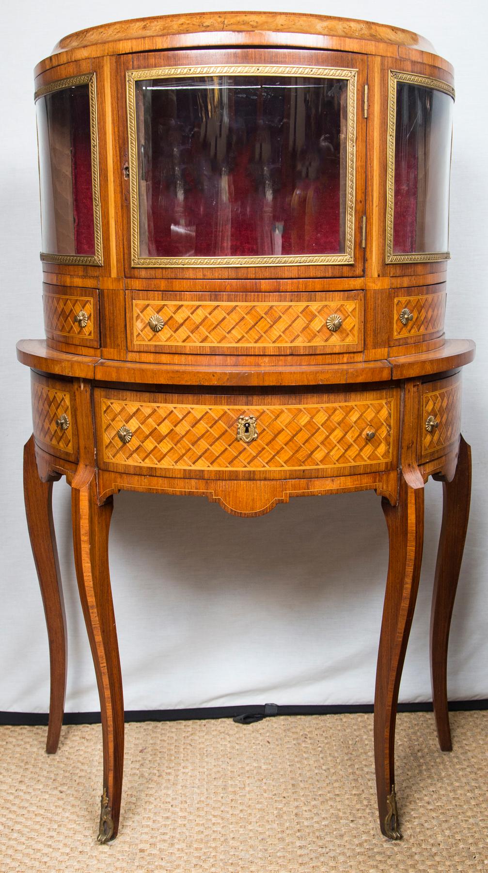 Marquetry inlay on mahogany. Center glass door, flanked by non-opening glass windows.
Three drawers below.
The base also with 3 drawers. Cabriole legs.