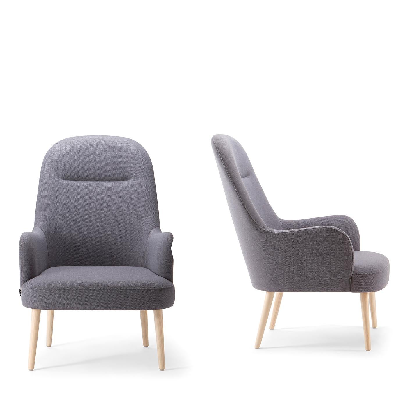 A refined addition to any living room or office decor, this splendid chair is characterized by classic lines and features a polyurethane foam-padded frame supported by natural ash wood legs. A carefully profiled high backrest towers over a large