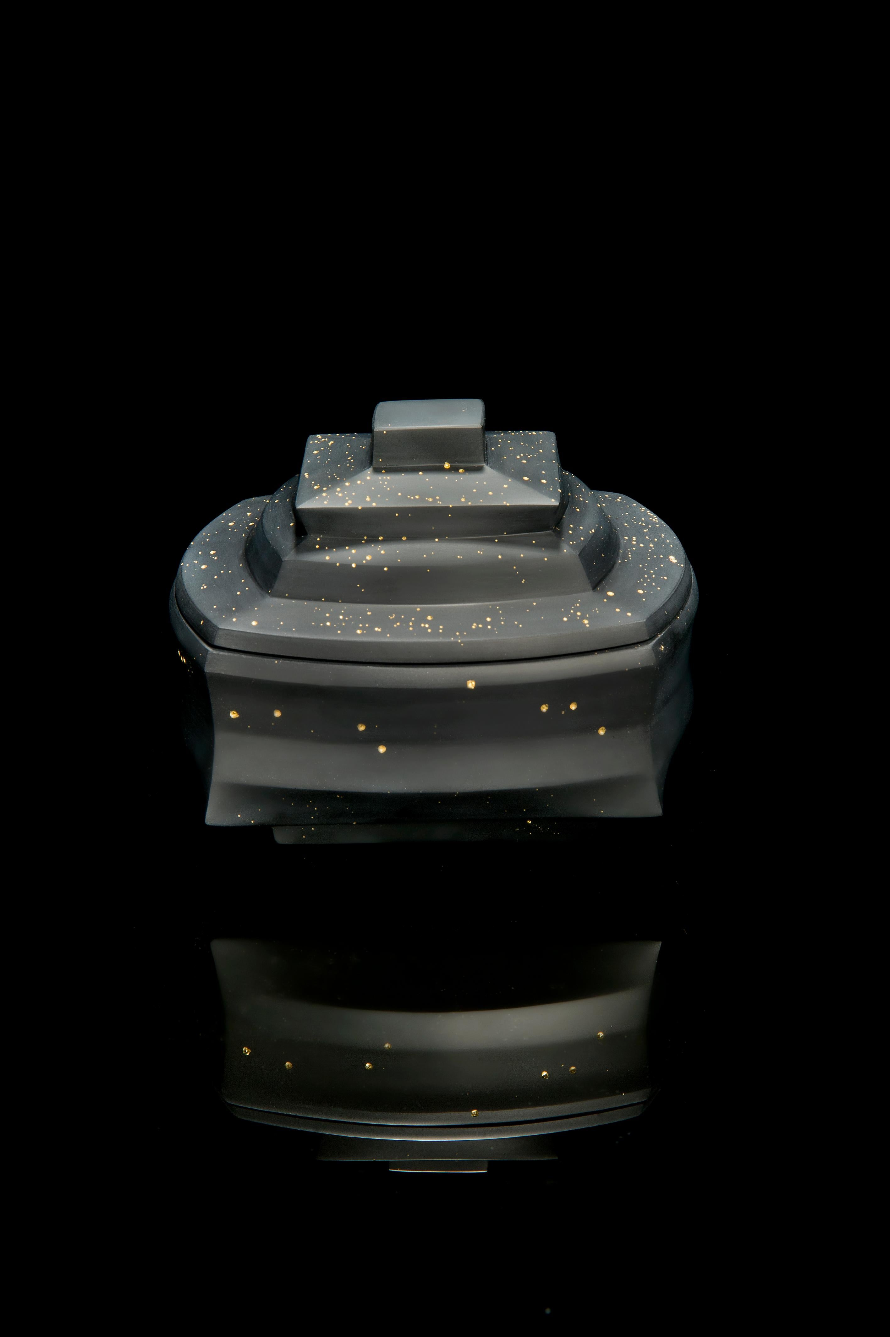 DAH 7-1 est une boîte à couvercle unique en verre moulé noir avec des feuilles d'or de 23,5 carats, réalisée par l'artiste sud-coréen Choi Keeryong. Lors du coulage du verre, de minuscules bulles y sont piégées. Avec cette pièce, l'artiste a traité