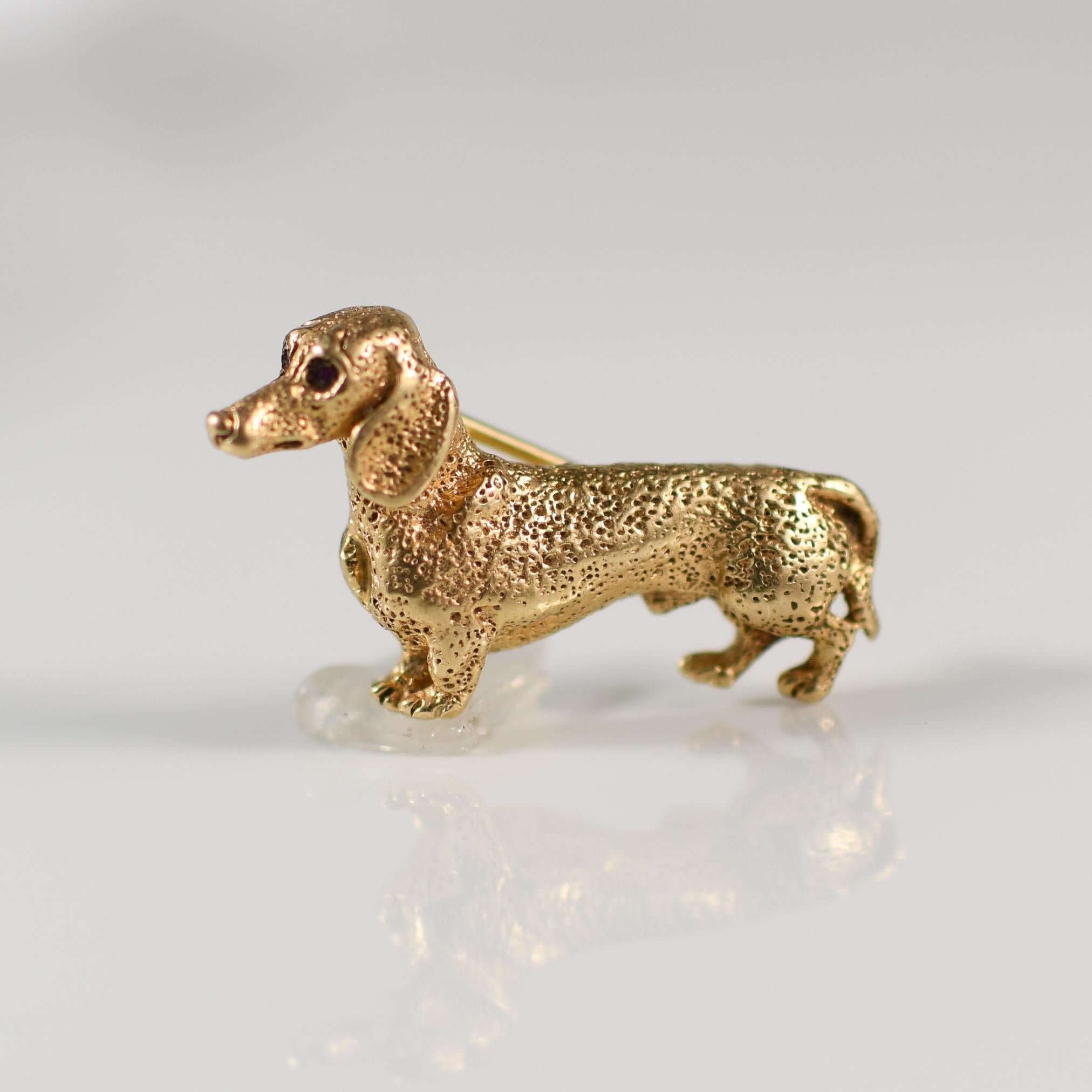 This exquisite 14K yellow gold Dachshund brooch by William Ruser showcases the charm and elegance of the beloved breed. Adorned with striking ruby eyes, the piece captures the Dachshund’s playful spirit and distinctive silhouette with meticulous