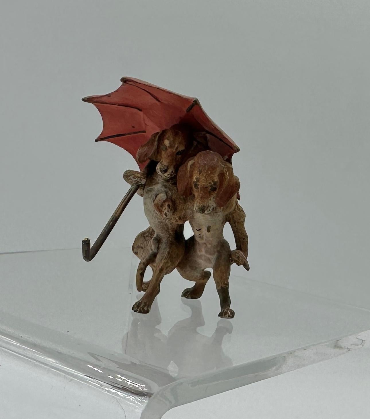THIS IS A SUPERB ANTIQUE AUSTRIAN VIENNA BRONZE OF TWO DACHSHUND DOGS WALKING UNDER AN UMBRELLA.
This wonderful antique Austrian Vienna Bronze (Bronze de Vienne, Wiener Bronze, Cold Painted Bronze) dates to circa 1900-1920.  The bronze is of the