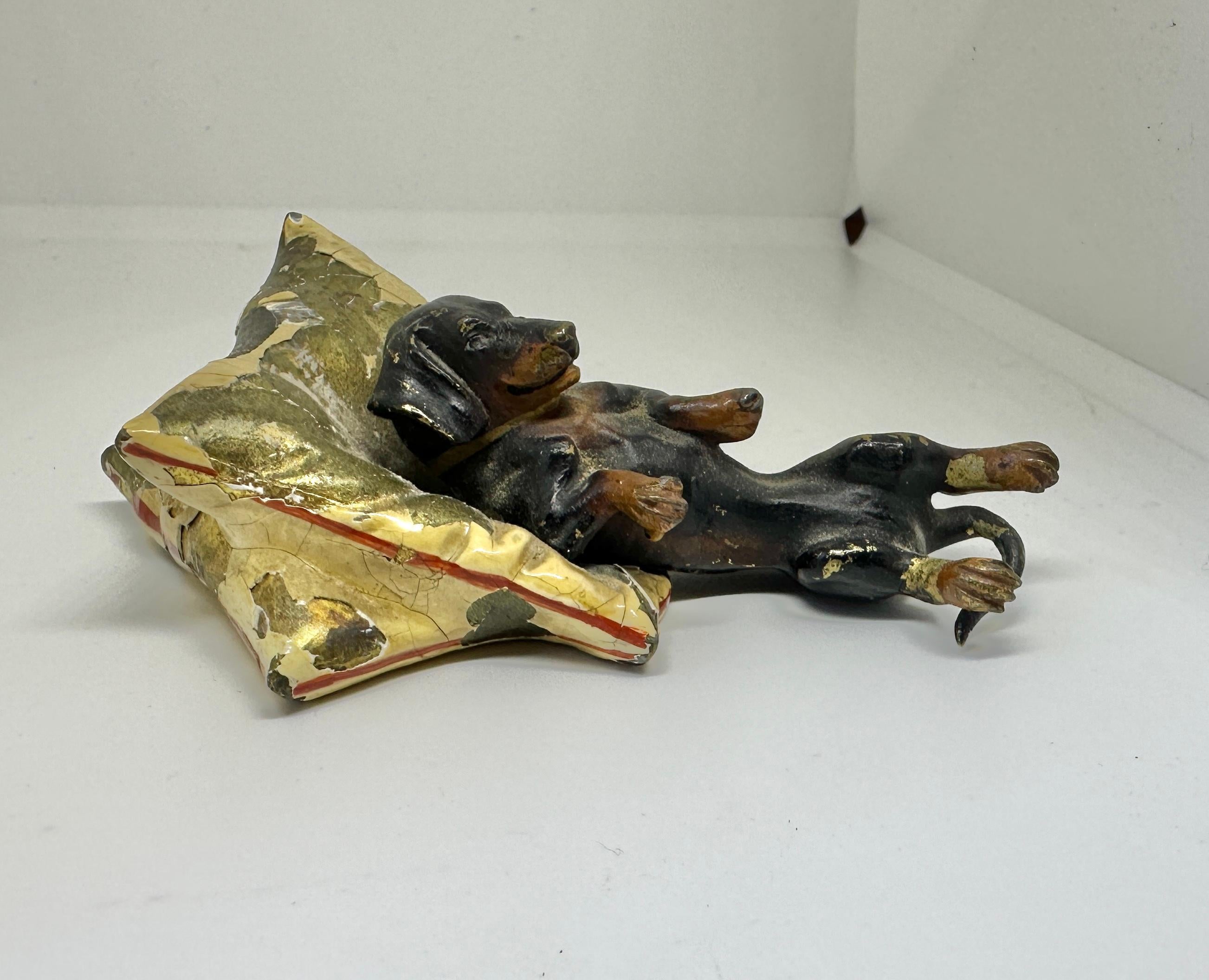 DIES IST EINE HERVORRAGENDE ANTIKE ÖSTERREICHISCHE WIENER BRONZE VON EINEM LIEBENSWERTEN DACKEL HUND AUF EINEM KISSEN LIEGEND.
Diese wunderbare antike österreichische Wiener Bronze (Bronze de Vienne, Wiener Bronze, Kaltbemalte Bronze) stammt aus der