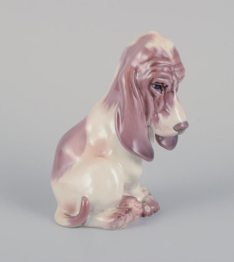 Dahl Jensen porcelain figurine of a sitting Basset Hound.
Model: 1065.
From the 1930s.
In perfect condition.
First factory quality.
Dimensions: H 14.0 cm x W 10.0 cm.