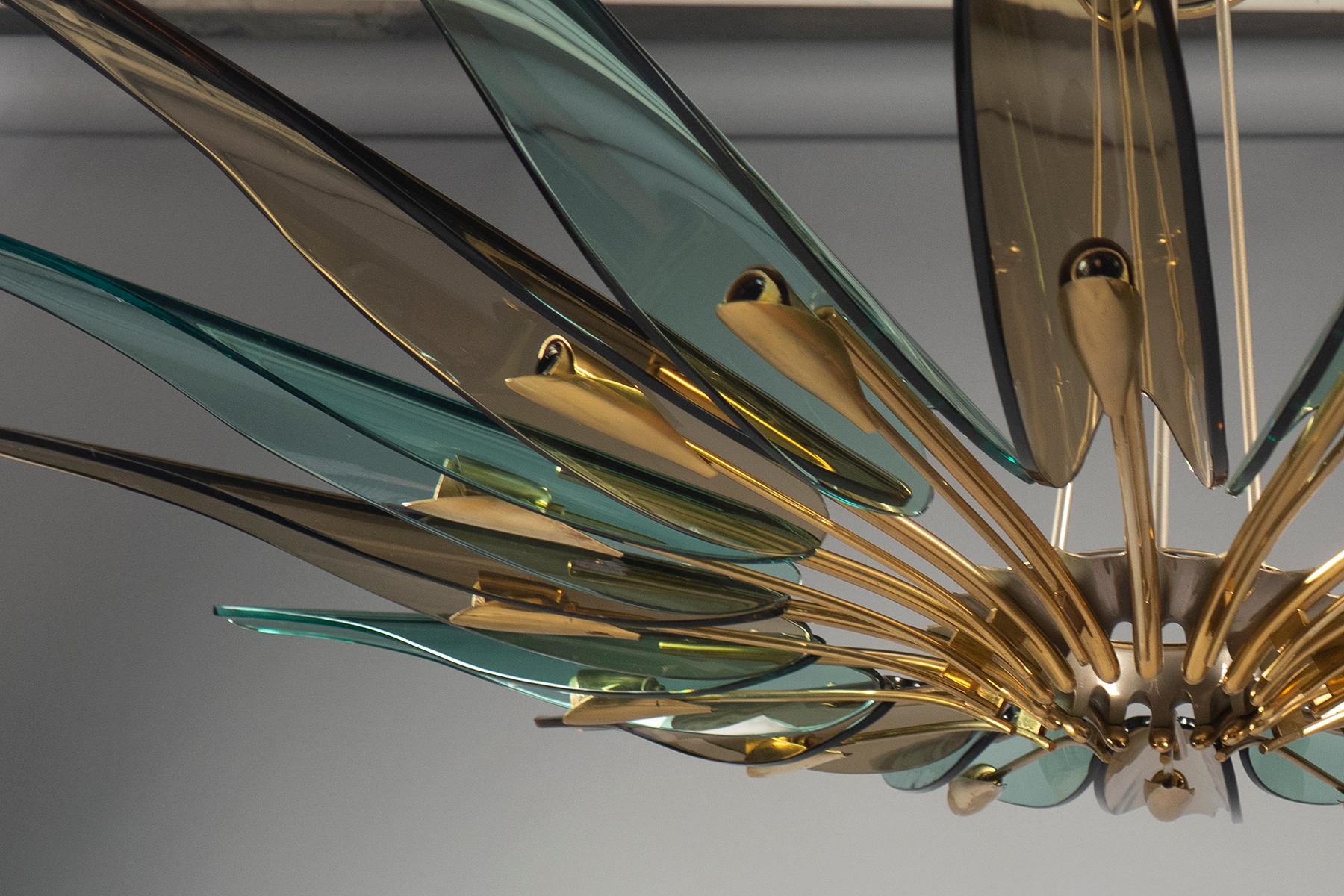 Chandelier composed of sixteen translucent green and amber glass “petals” mounted to a radial brass structure, suspended from three rods and matching canopy. Fontana Arte model number 1563. Literature: Franco Deboni’s Fontana Arte: Gio Ponti, Pietro
