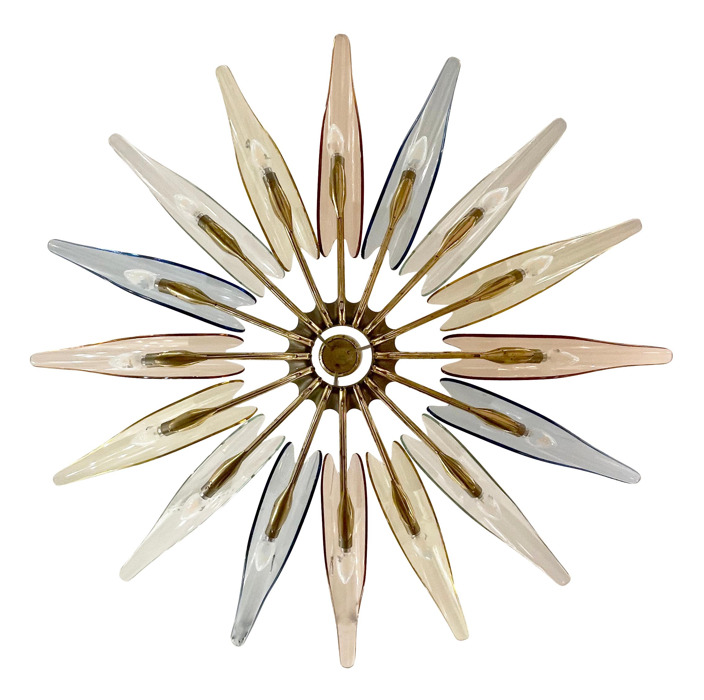 The Dahlia chandelier, Model 1563, designed by Max Ingrand for Fontana Arte in the 1950s is one of the most coveted and iconic pieces of Italian Mid-Century design. This multi-color example has alternating blue, rose, yellow and clear glass petals