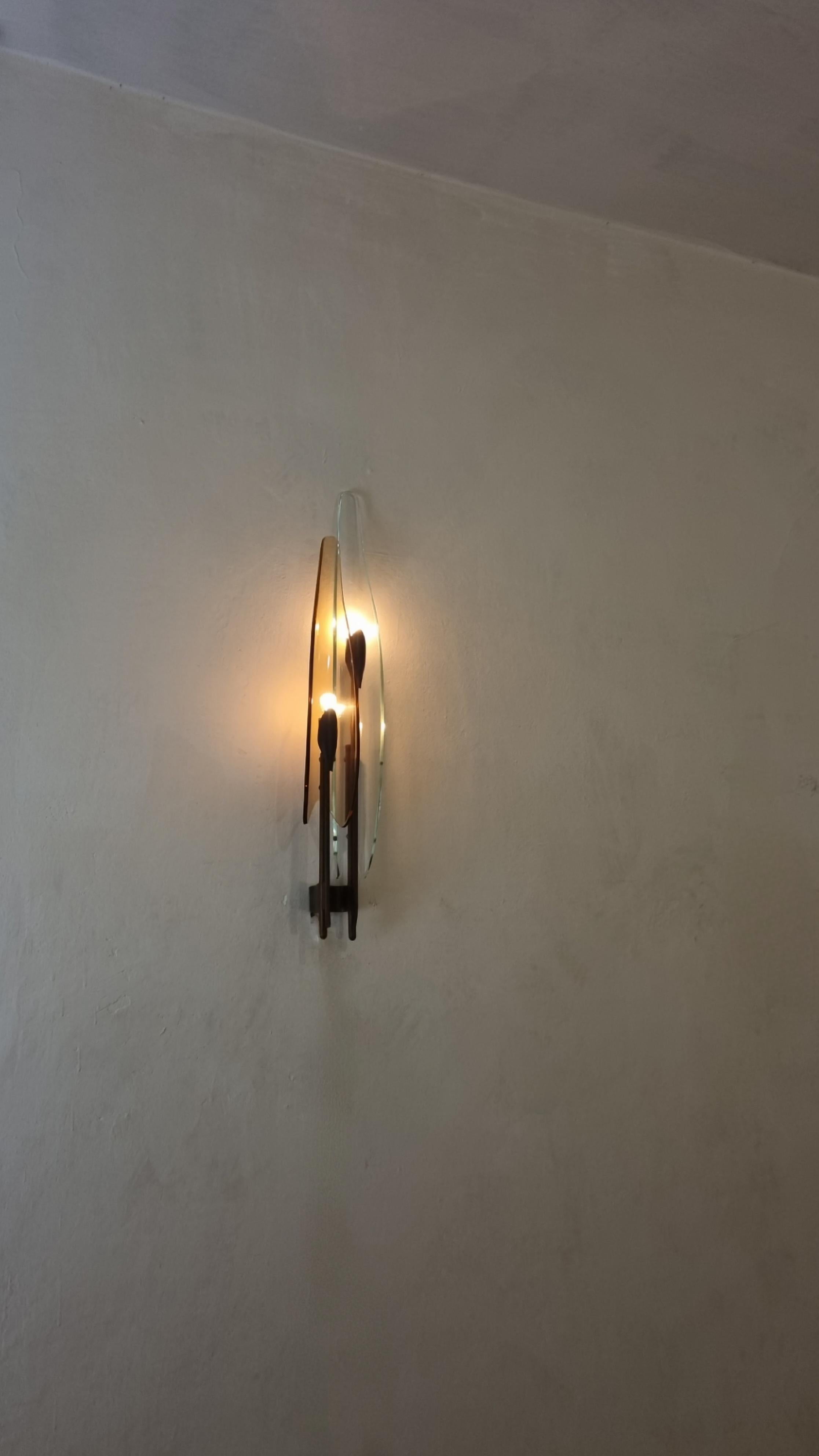Rara lampada a parete mod. 1461 Dahlia disegnata da Max Ingrand per Fontana Arte nel 1955.
Struttura in ottone, cristalli colorati nei toni del rosa e trasparente, diffusori in cristallo curvato e molato.
Eccellenti condizioni, patina del