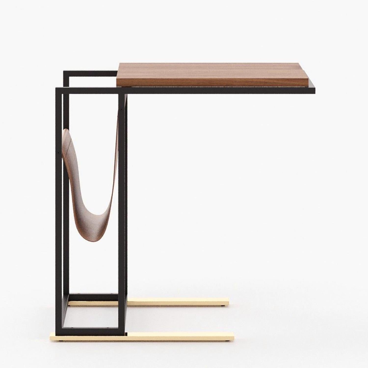Table d'appoint Daily avec structure de base en fer peint en noir en finition mate
et avec des pieds en acier inoxydable poli et doré. Avec pièce de rangement
en cuir véritable en finition marron et avec un plateau en bois plaqué noyer.
Egalement