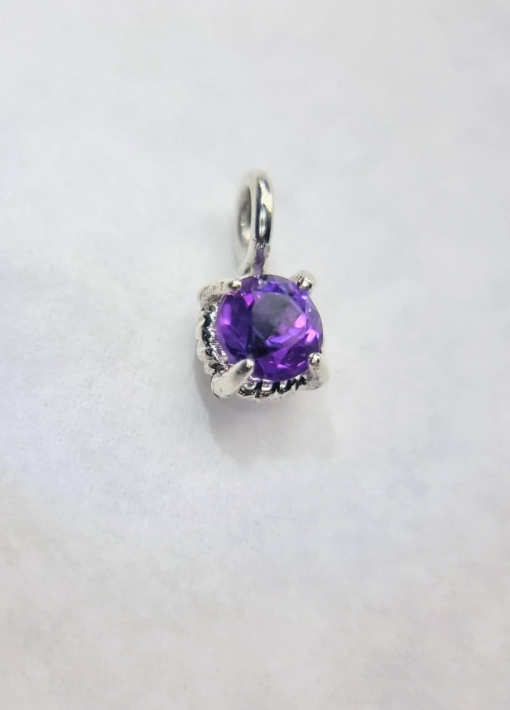 La sophistication subtile rencontre la couleur enchanteresse dans ce délicat pendentif en améthyste, avec une améthyste naturelle ronde de 6 mm de diamètre sertie dans un élégant design à quatre branches torsadées. La riche teinte violette de la