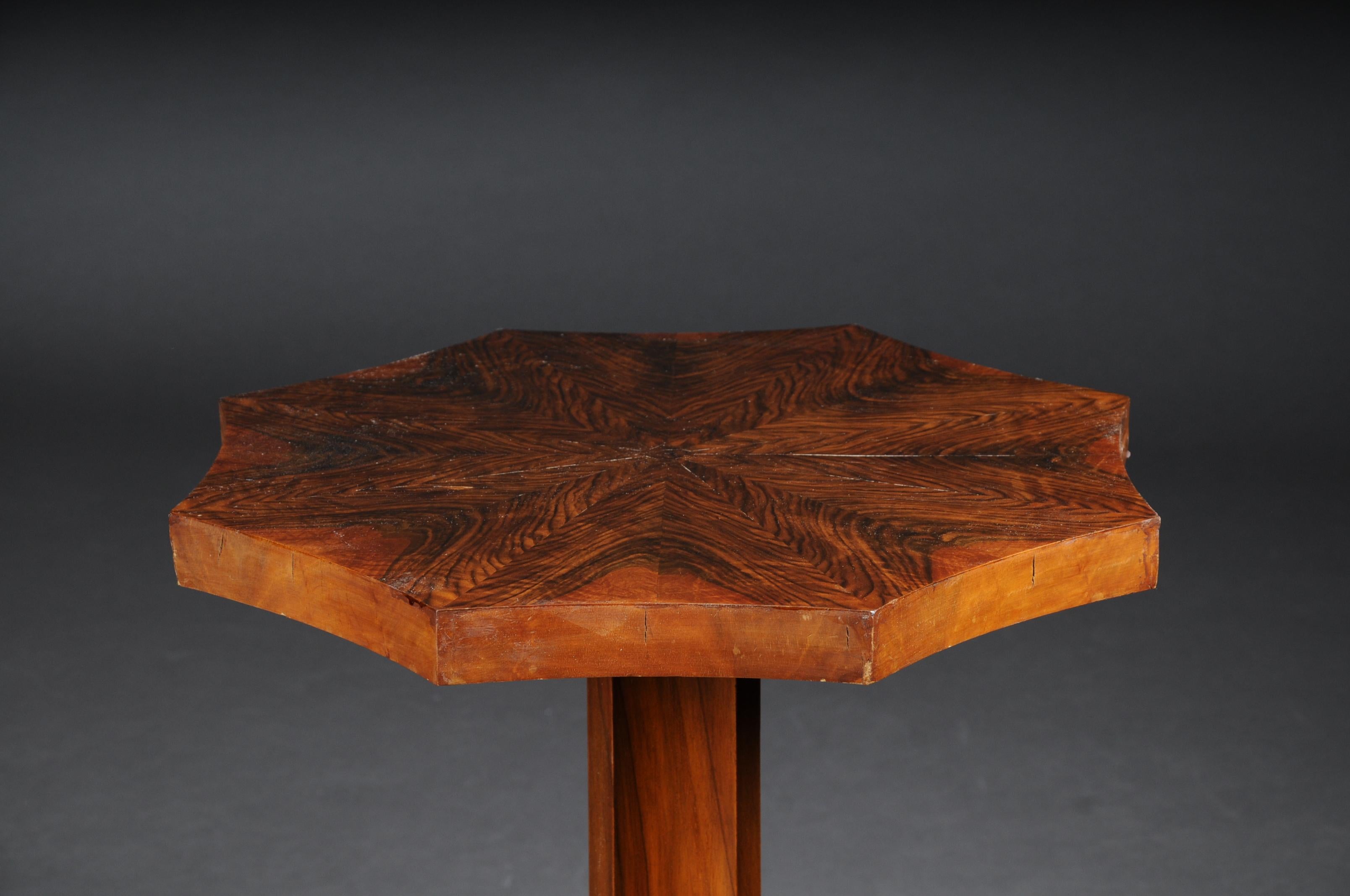 Dainty Art Deco side table root veneer around 1930.

Solid wood with root veneer. Star-shaped cover plate and multi-edged balustrade shaft.
Base also star-shaped. Probably France around 1930.

(A-171).