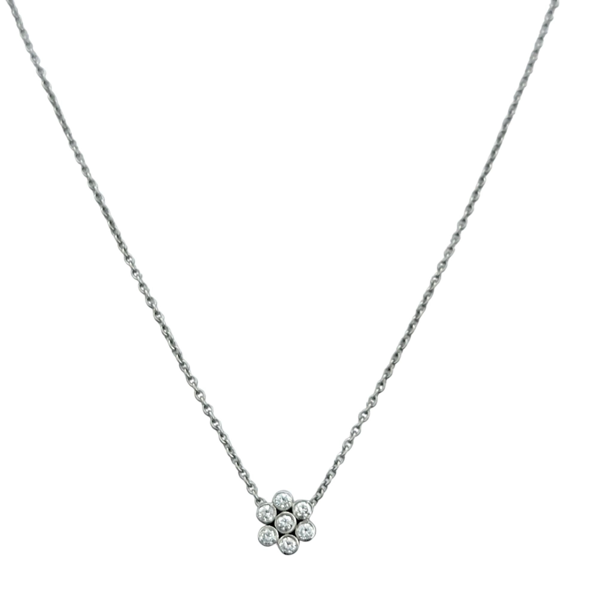 Eleganza e abbagliante, questa collana con ciondolo in platino cattura la bellezza di un singolo fiore in un'eleganza senza tempo. Sospeso da una catena di 16,5 pollici, il pendente è disegnato come un piccolo fiore formato da diamanti rotondi