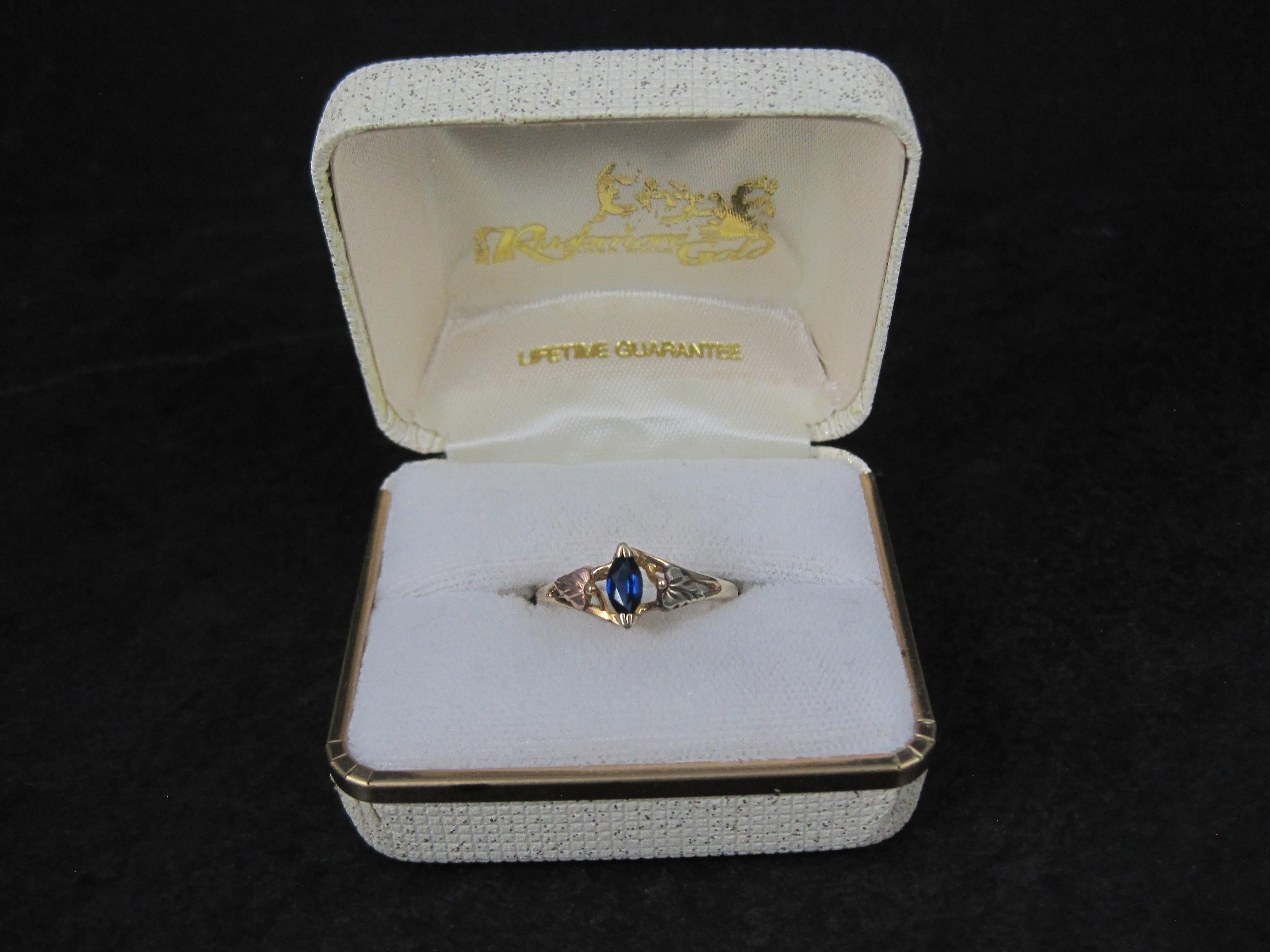Dieser bezaubernde Ring ist aus Black Hills Gold mit einem Saphir im Marquiseschliff.
Der Ring selbst ist aus 10 Karat Gelbgold. Die Blätter aus Roségold und Grüngold sind aus 12 Karat Gold. 
Der Saphir misst 3x5 mm.

Größe: 8

Markierungen: 10K,