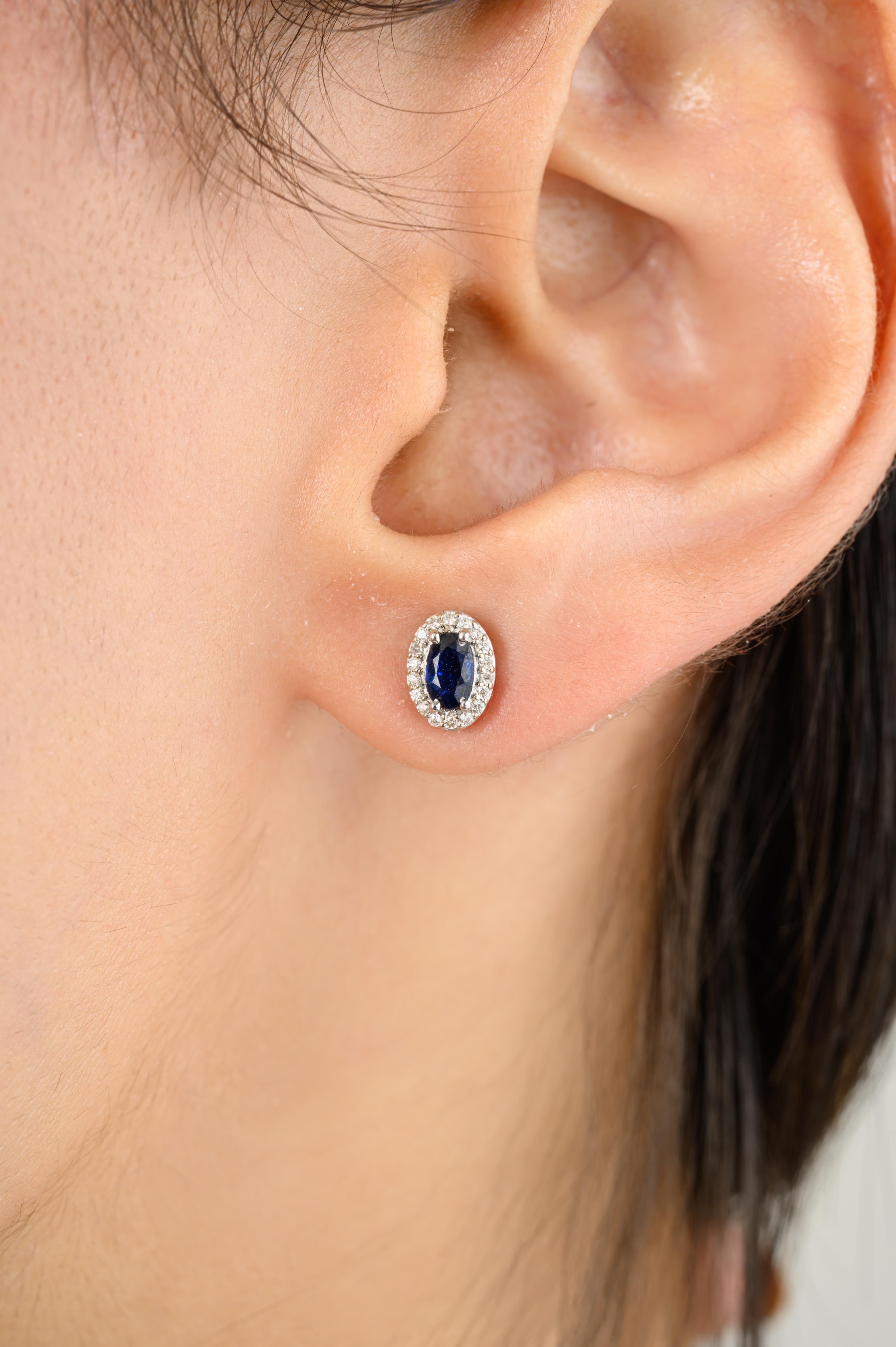Dainty Blue Sapphire Stud Earrings with Diamond Around in 18K Gold to make a statement with your look. You shall need stud earrings to make a statement with your look. These earrings create a sparkling, luxurious look featuring oval cut blue