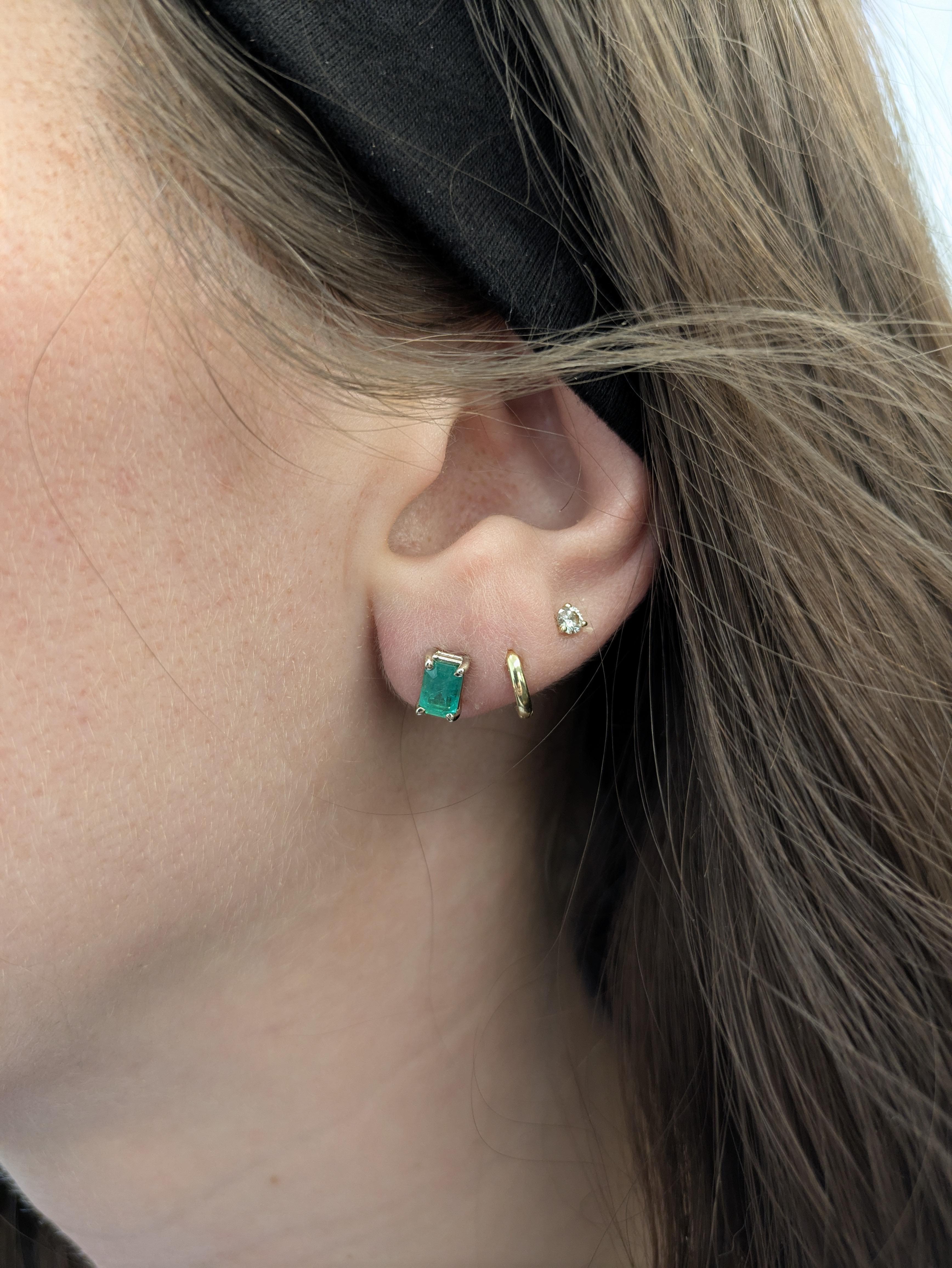 These 1.02 carat emerald-cut studs (6x4mm) shine with timeless beauty. Set in solid 14K white gold, the rich green hue of the natural emeralds adds a sophisticated pop of color to any look.

Specifications:

Item Type: Solitaire Studs
Center