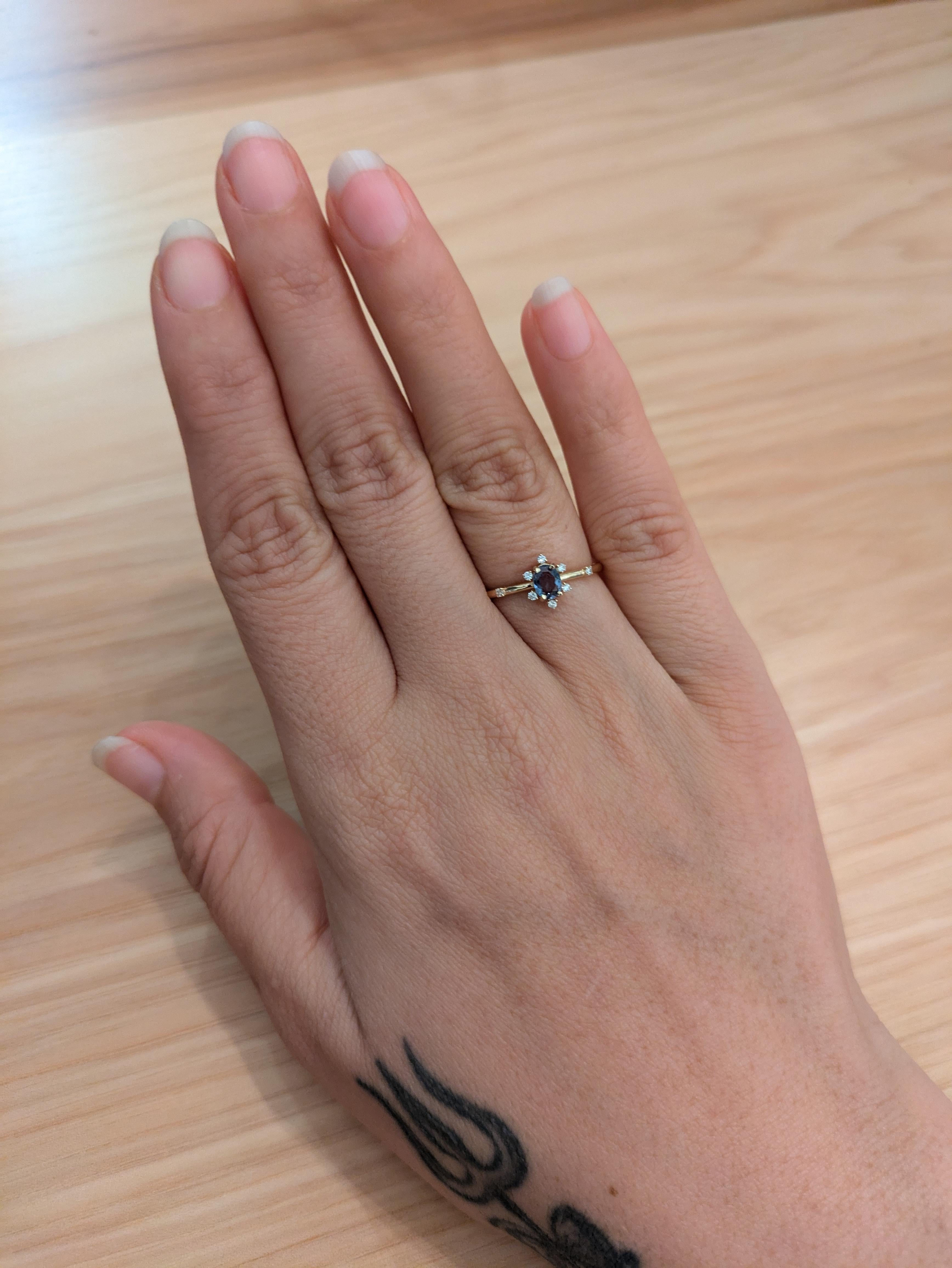 This ring features a rare and beautiful natural color changing Alexandrite set in 14k Gold with natural earth mined diamond accents. A dainty ring design perfect for an eye catching engagement or anniversary. This ring also makes a beautiful June