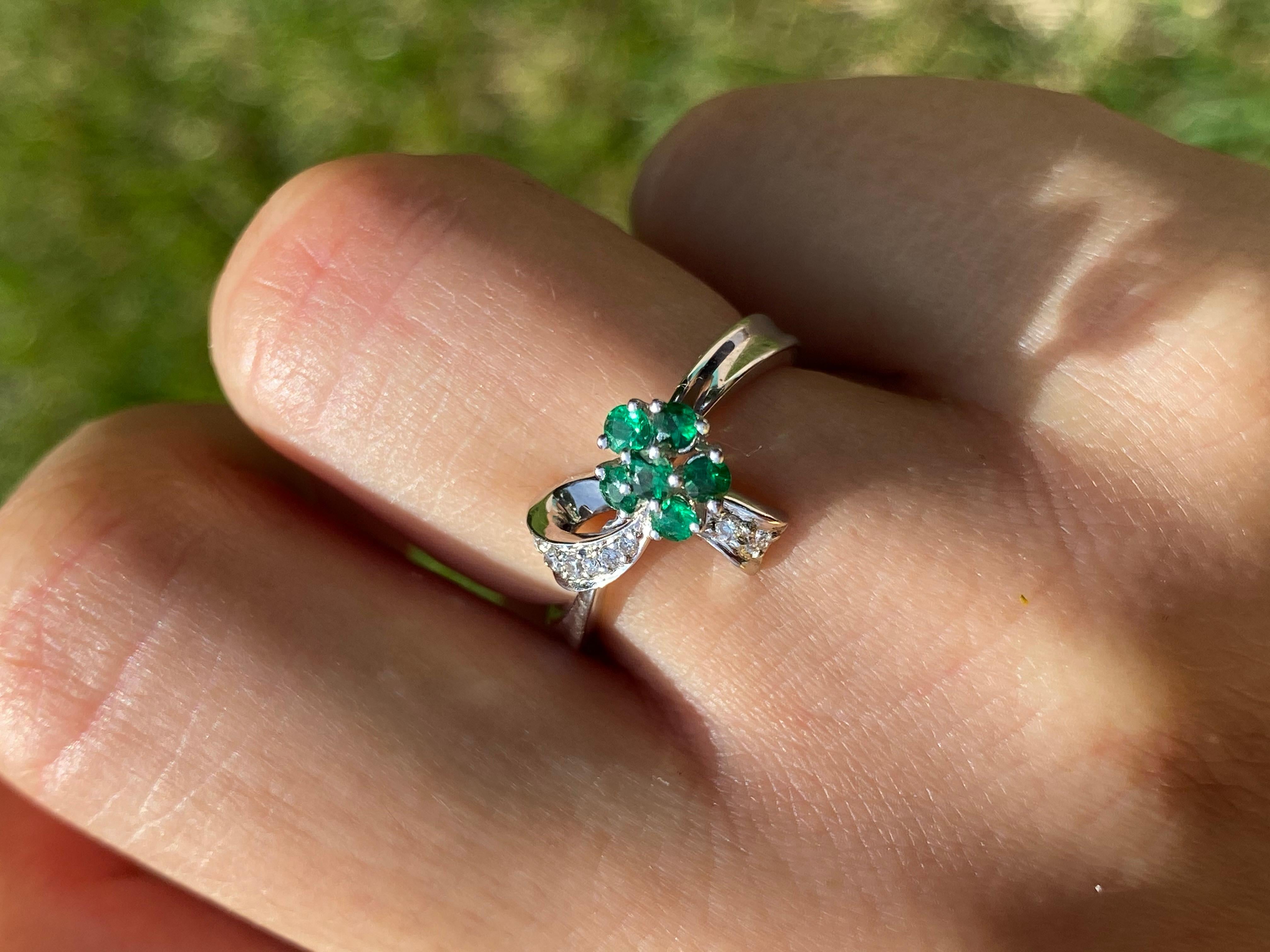Centering six Round-Brilliant Cut Brazil Emeralds, accented by 0.07 Carats of Round-Brilliant Diamonds, and set in 14K White Gold, this dainty ring is designed into a classic 
