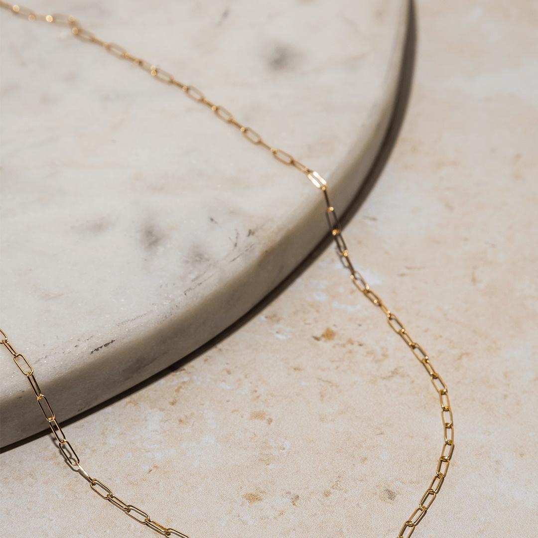 Looking for a dainty, yet eye-catching necklace? Look no further than this gold paperclip chain necklace! This perfect layering piece can be worn on its own or with a pendant for a personalized look. And who doesn't love a good paperclip chain?