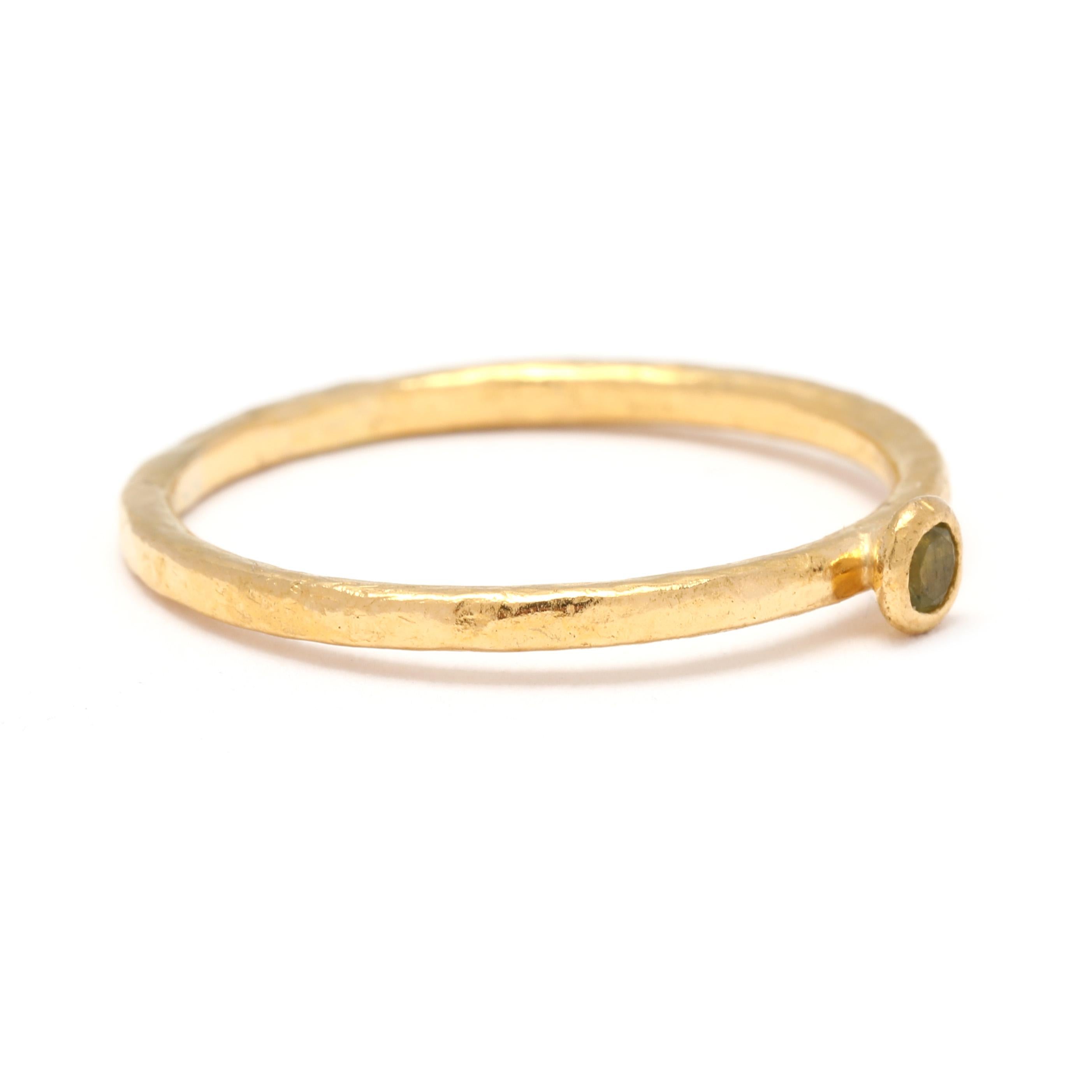 This dainty peridot ring is crafted in 24k yellow gold and features a beautiful round-cut peridot gemstone. The peridot gemstone is dainty and adds some uniqueness to the simple ring. The thin band adds a delicate and feminine touch to the design,