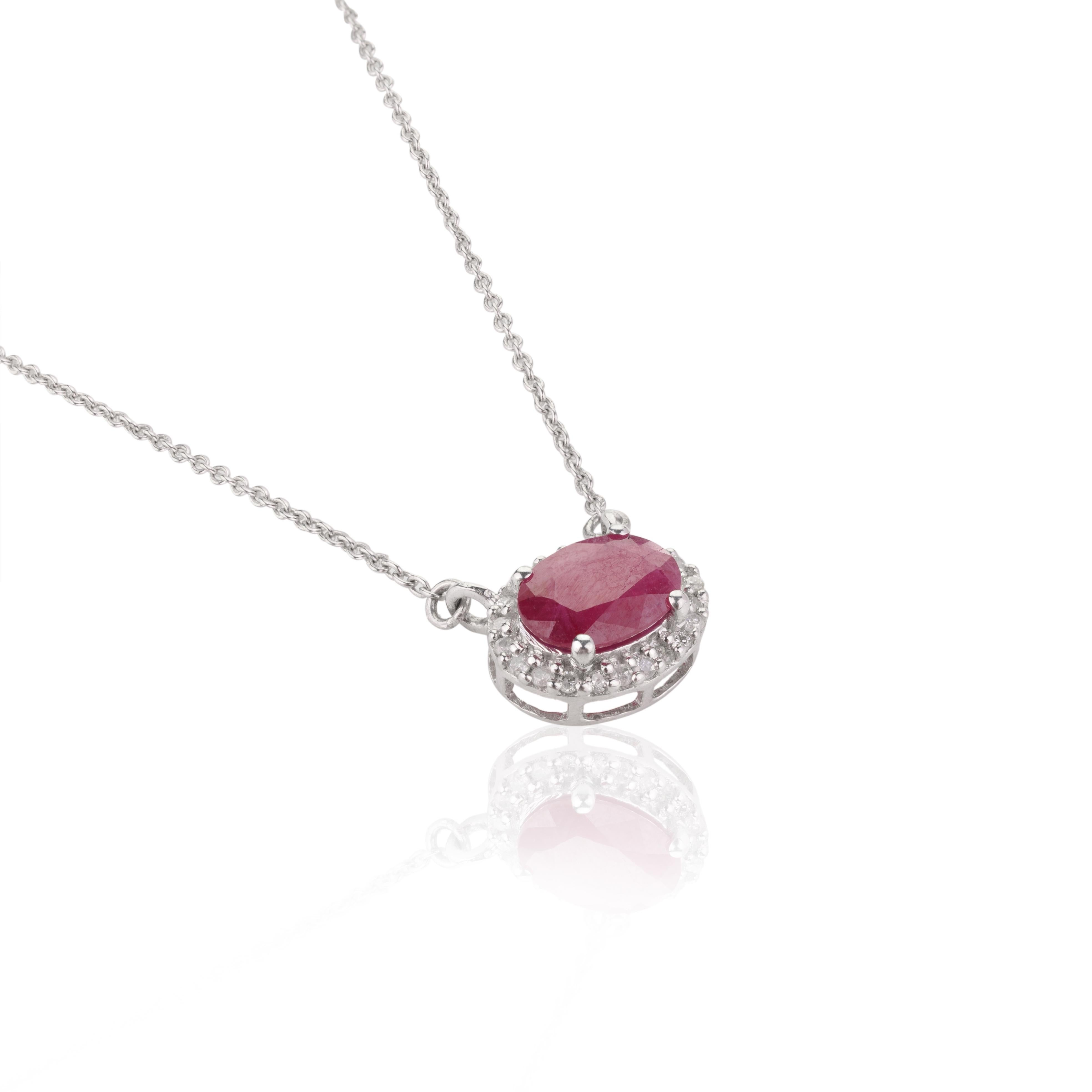 Oval Ruby and Diamond Halo Pendant Necklace in 14K Gold studded with ruby with halo of diamonds. This stunning piece of jewelry instantly elevates a casual look or dressy outfit. 
Ruby improves mental strength. 
Designed with oval cut ruby with