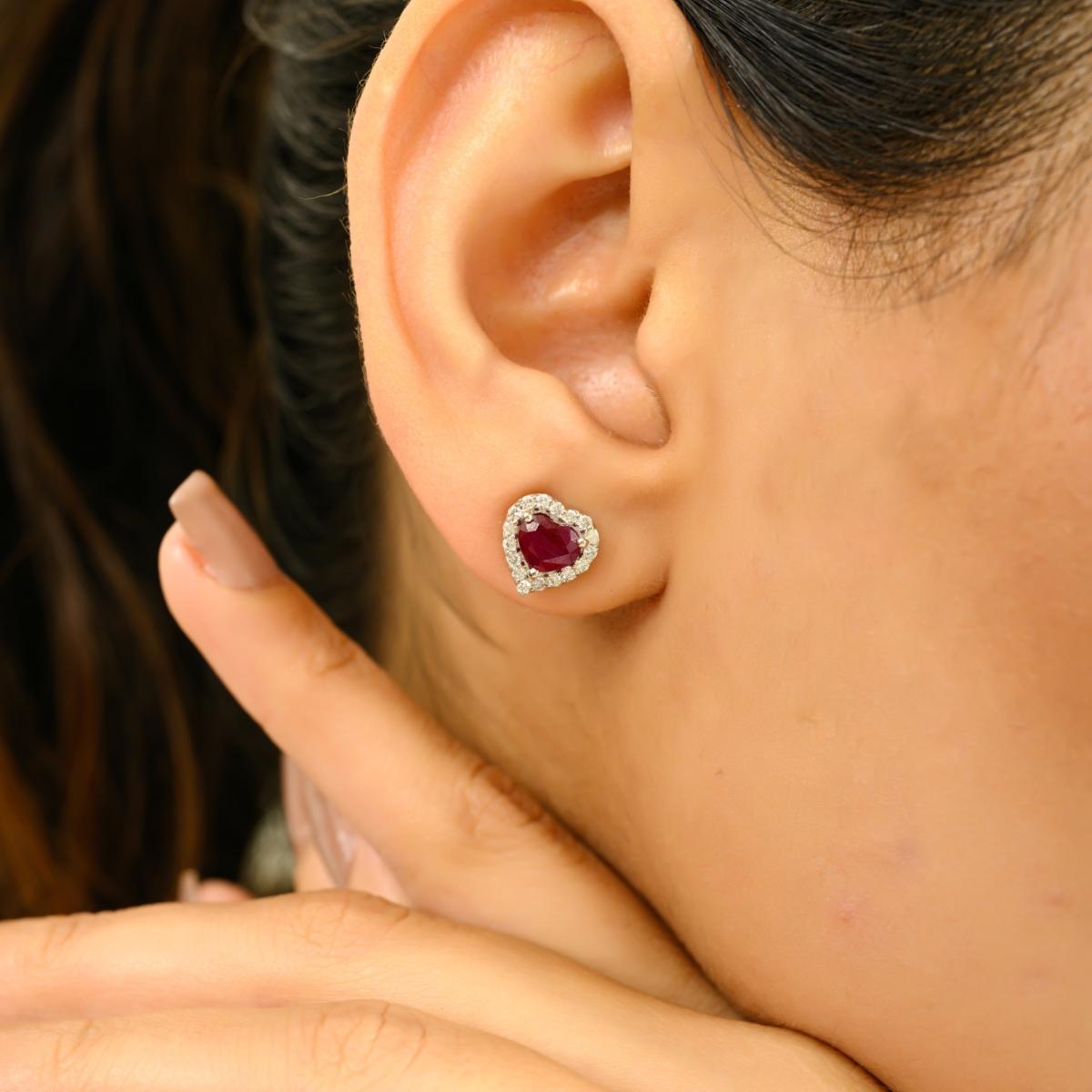Zelebrieren Sie Liebe und Eleganz mit diesen bezaubernden herzförmigen Ohrsteckern aus glänzendem 14-karätigem Weißgold. Jeder Ohrring besteht aus einem leuchtend roten Edelstein mit einem Gesamtgewicht von 1,67 Karat, der von einem schillernden