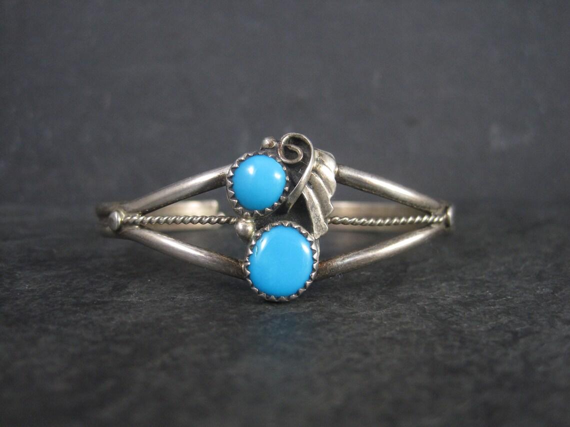 This beautiful, dainty Southwestern cuff bracelet is sterling silver with turquoise stones.

The face of this bracelet measures 13/16 of an inch north to south.
It has an inner circumference of 6 inches including the 1 inch gap.
Weight: 10.6