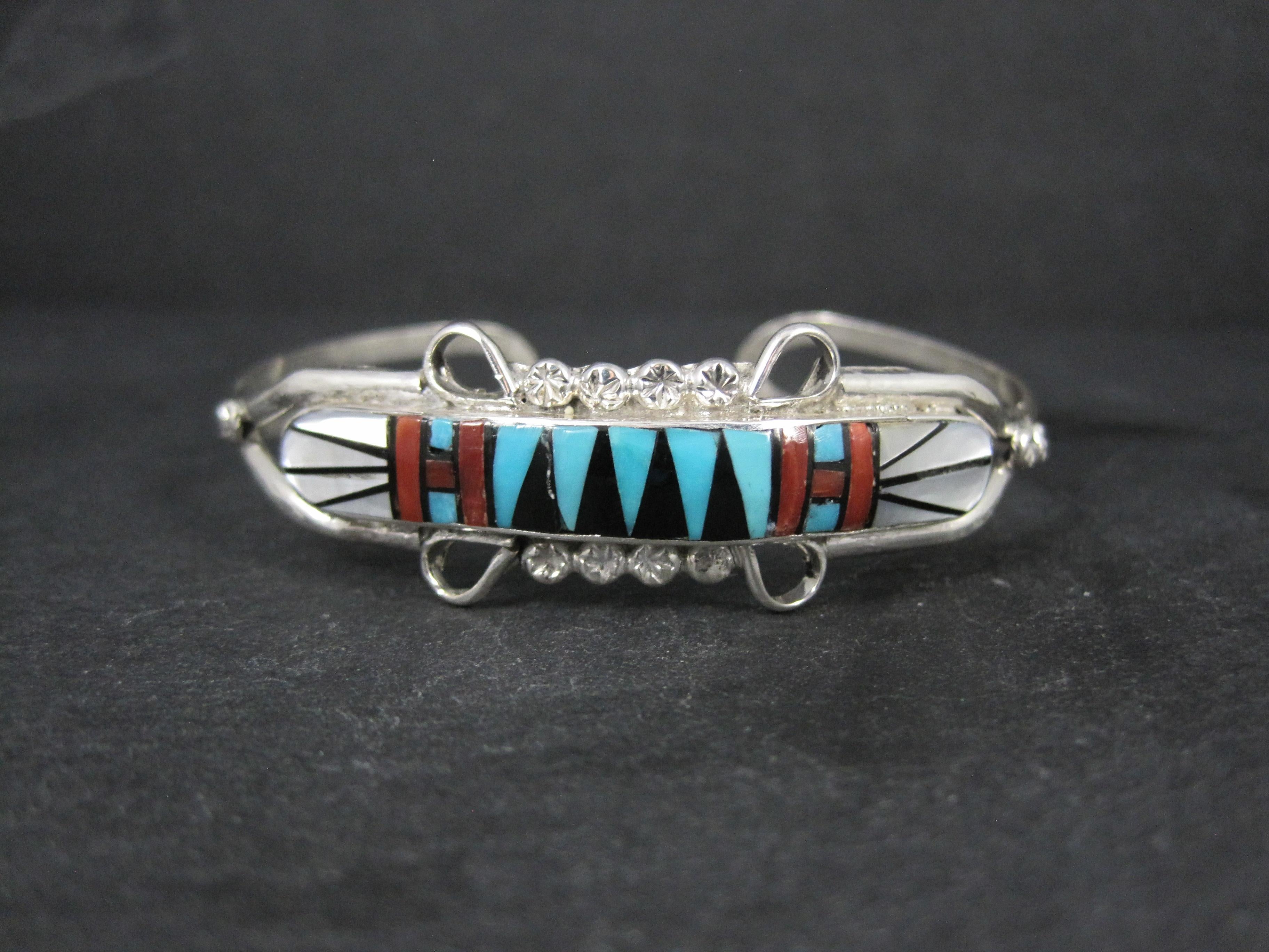 Este precioso brazalete es de plata de ley con incrustaciones de turquesa, coral, nácar y azabache.
Mide 3/4 de pulgada en su punto más ancho.
Tiene una circunferencia interior de 15 cm, incluido el hueco.
Hecha por el orfebre zuni Ola