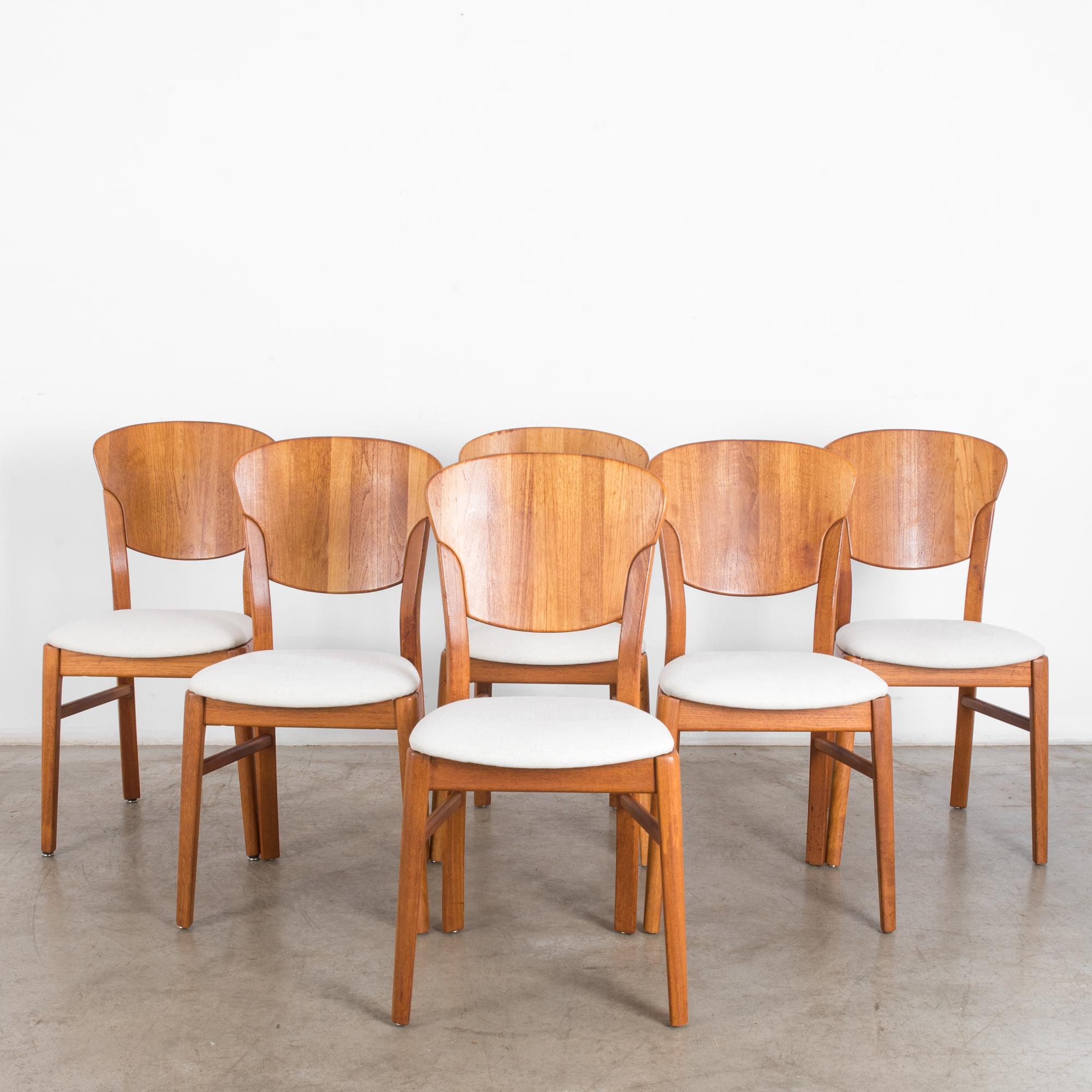 A set of six 1960s dining chairs by Danish furniture maker Glostrup Møbelfabrik. Clean design in bright and natural, warmly polished wood represents a Scandinavian Modernist sensibility. The subtle curve of the backrest emulates the arch of the