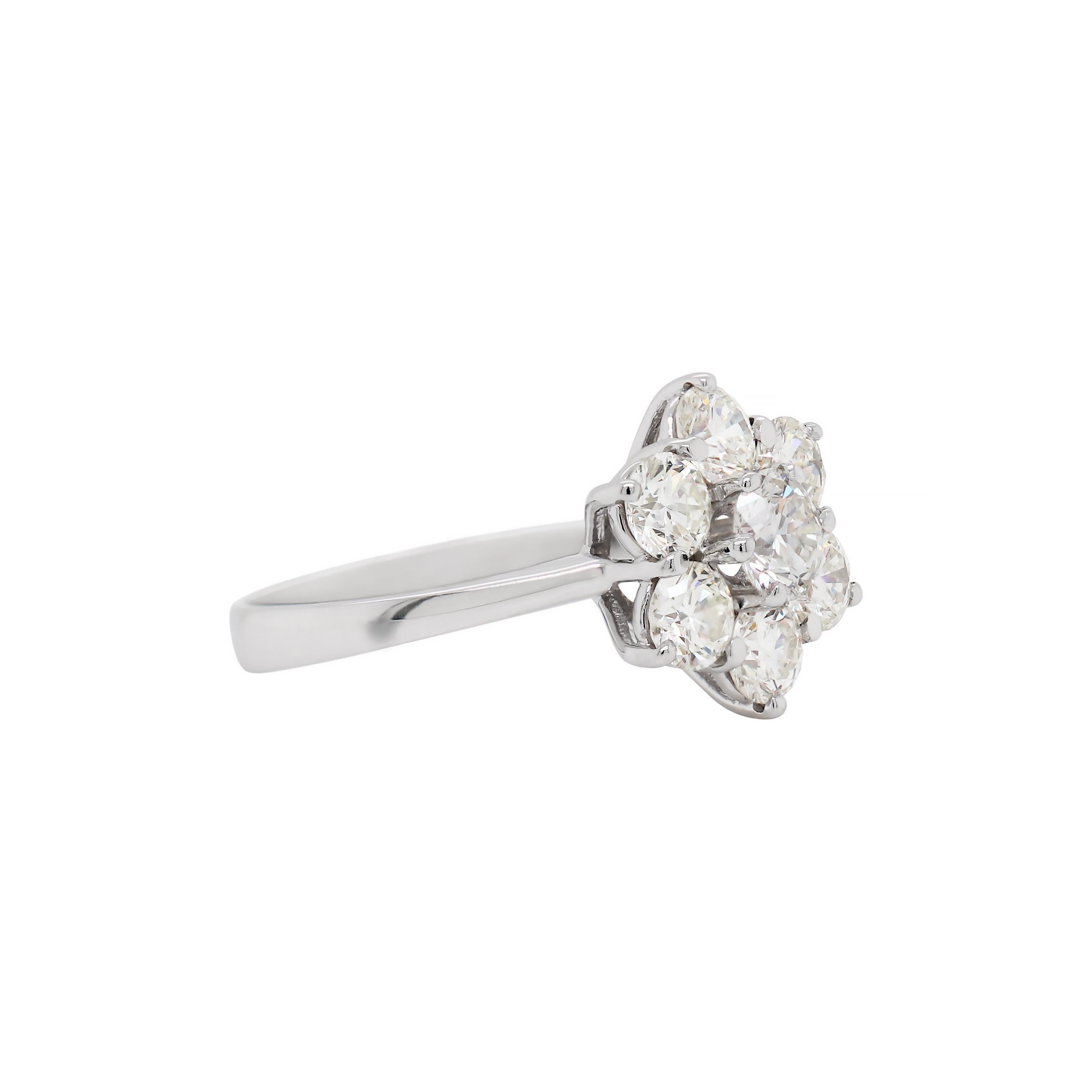 This beautiful classic diamond cluster features seven fine quality round brilliant cut diamonds weighing approximately 3.40ct in total, all claw set in an open back 18 carat white gold mount. Hallmarked, England, 2006. UK finger size 'S 1/2'.