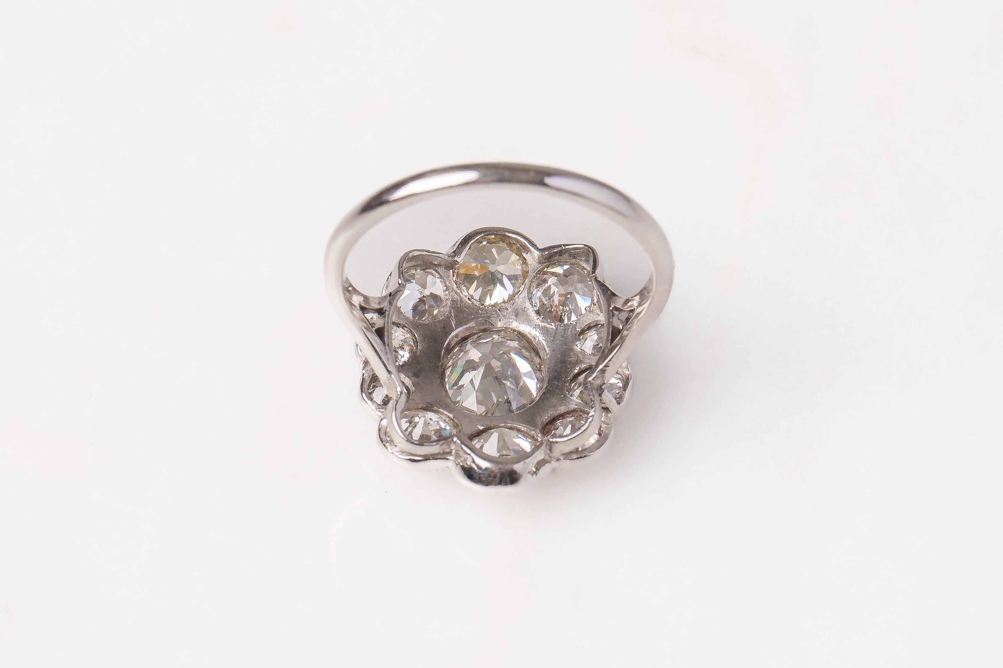 Ein Diamantring aus dem frühen 20. Jahrhundert, besetzt mit kissenförmigen europäischen Old-Mine-Diamanten, montiert in Weißgold. 10 Diamanten umgeben einen zentralen Diamanten von schätzungsweise 1 Karat. Geschätztes Gesamtgewicht der Diamanten 3
