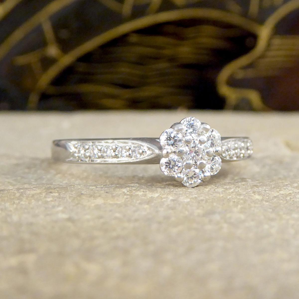 Embrace the delicate charm and exceptional elegance of this Daisy Diamond cluster ring. Crafted in the finest platinum, this exquisite ring features a dazzling cluster of diamonds arranged in a charming daisy pattern, complemented by