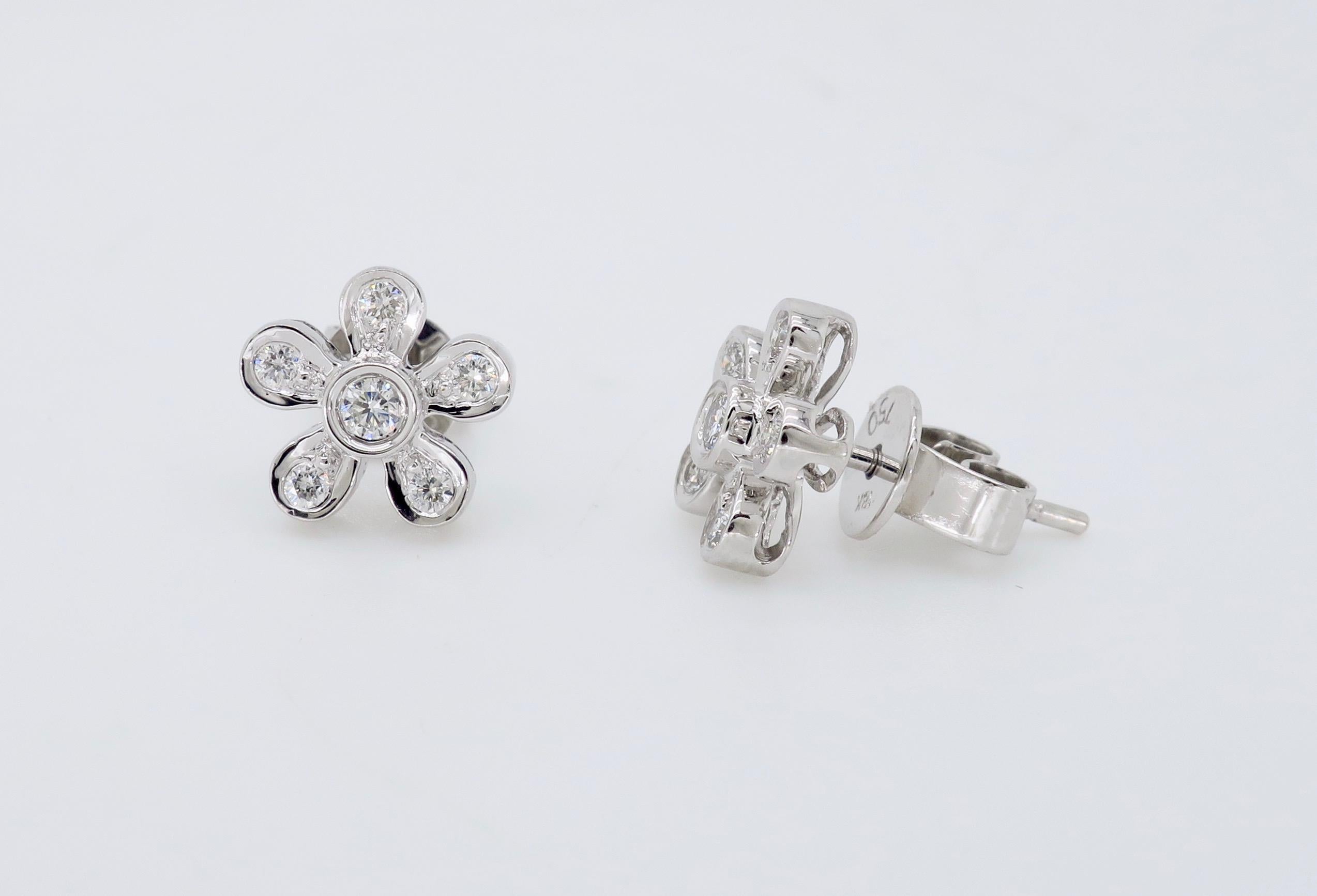 Daisy shaped Round Brilliant Cut diamond earrings crafted in 18k white gold.

Diamond Carat Weight: Approximately .24CTW 
Diamond Cut: Round Brilliant Cut 
Color: Average H-J
Clarity: Average VS
Metal: 18K White Gold
Marked/Tested: Earrings Tested