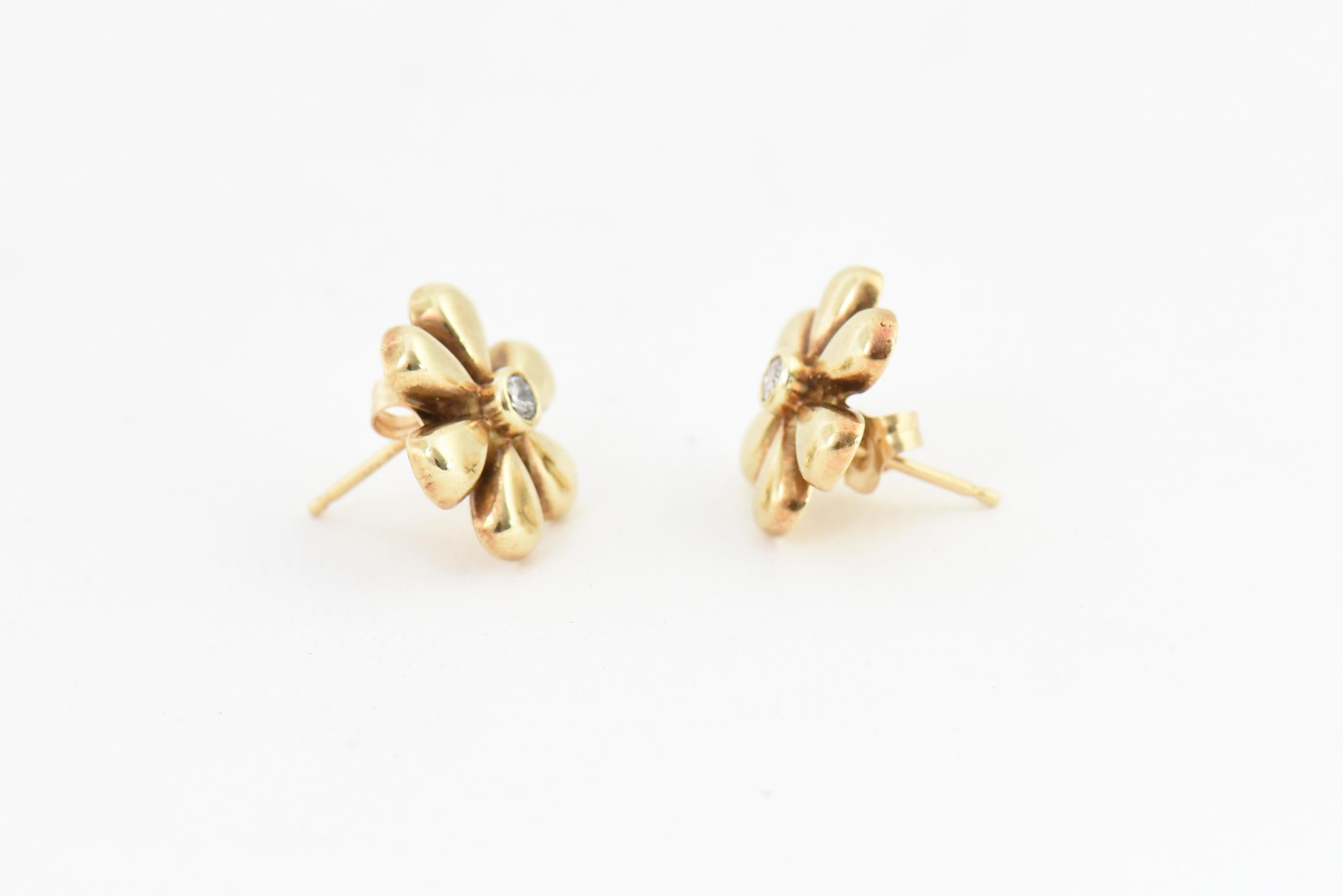 14K yellow gold daisy earrings set with a .07 carat diamond in the center of each. Post backs. Marked: 14K.