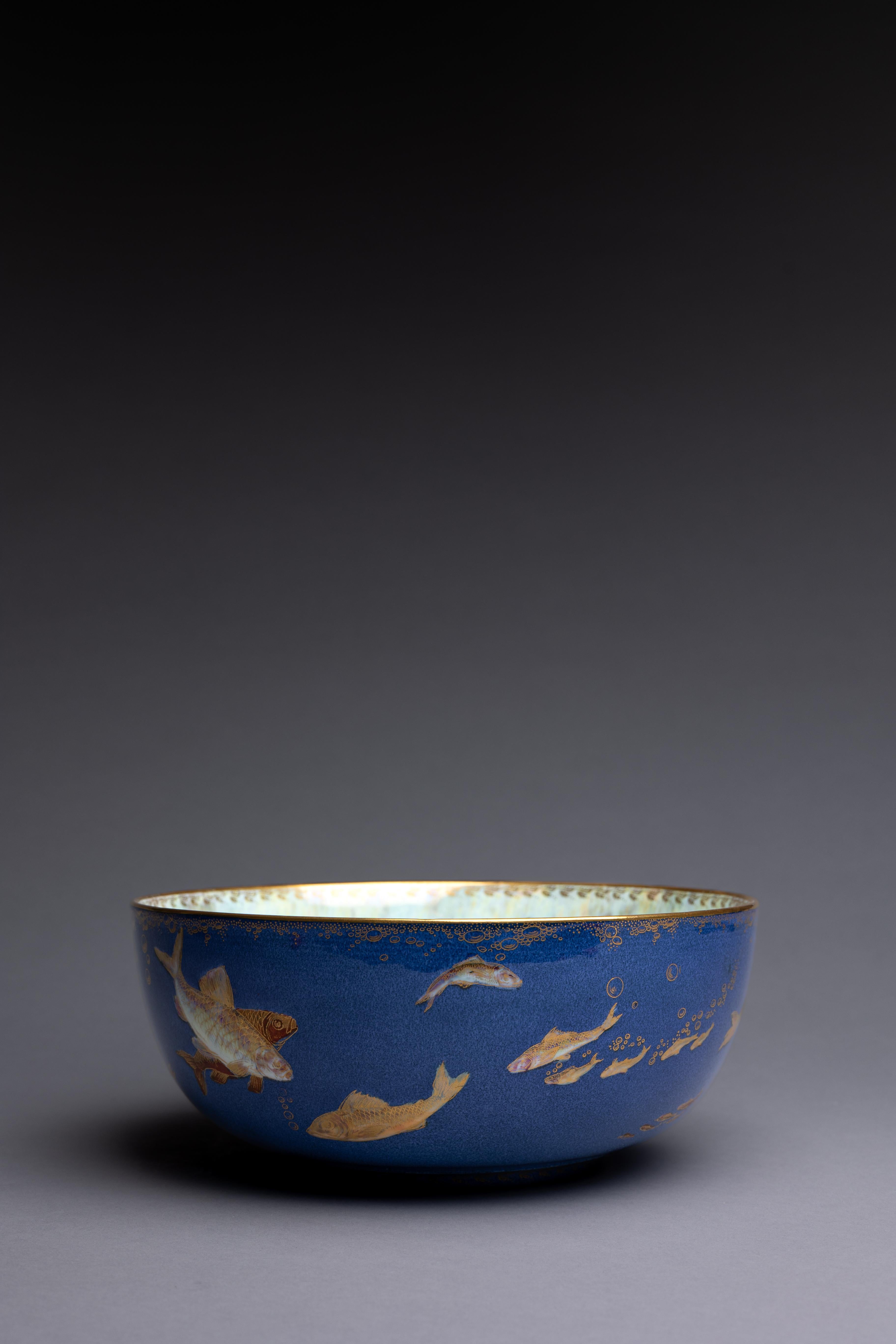 Un bol en porcelaine d'os bleu poudre conçu par Daisy Makeig-Jones pour Wedgwood vers 1915, joliment décoré d'un banc de poissons nageurs.

Ce superbe bocal à poisson bleu poudre est un hommage aux débuts de Daisy Makeig-Jones chez Wedgwood. En