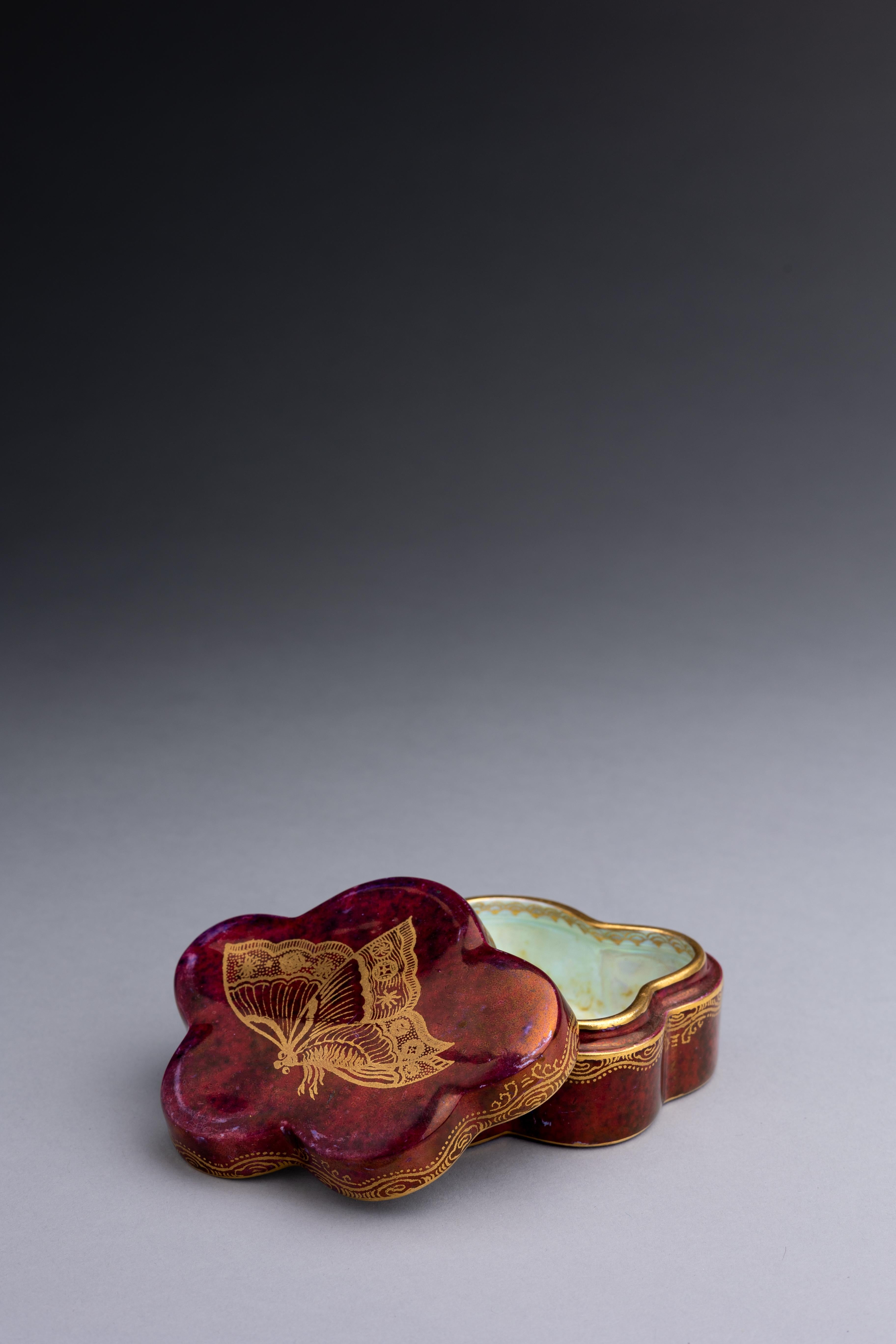 A ruby lustre box with mother-of-pearl lustre interior and decorated with polychrome butterflies in gold, designed by Daisy Makeig-Jones circa 1920.

This pattern, Z4827, was number 5 of the revolutionary First Ten Lustres range introduced by