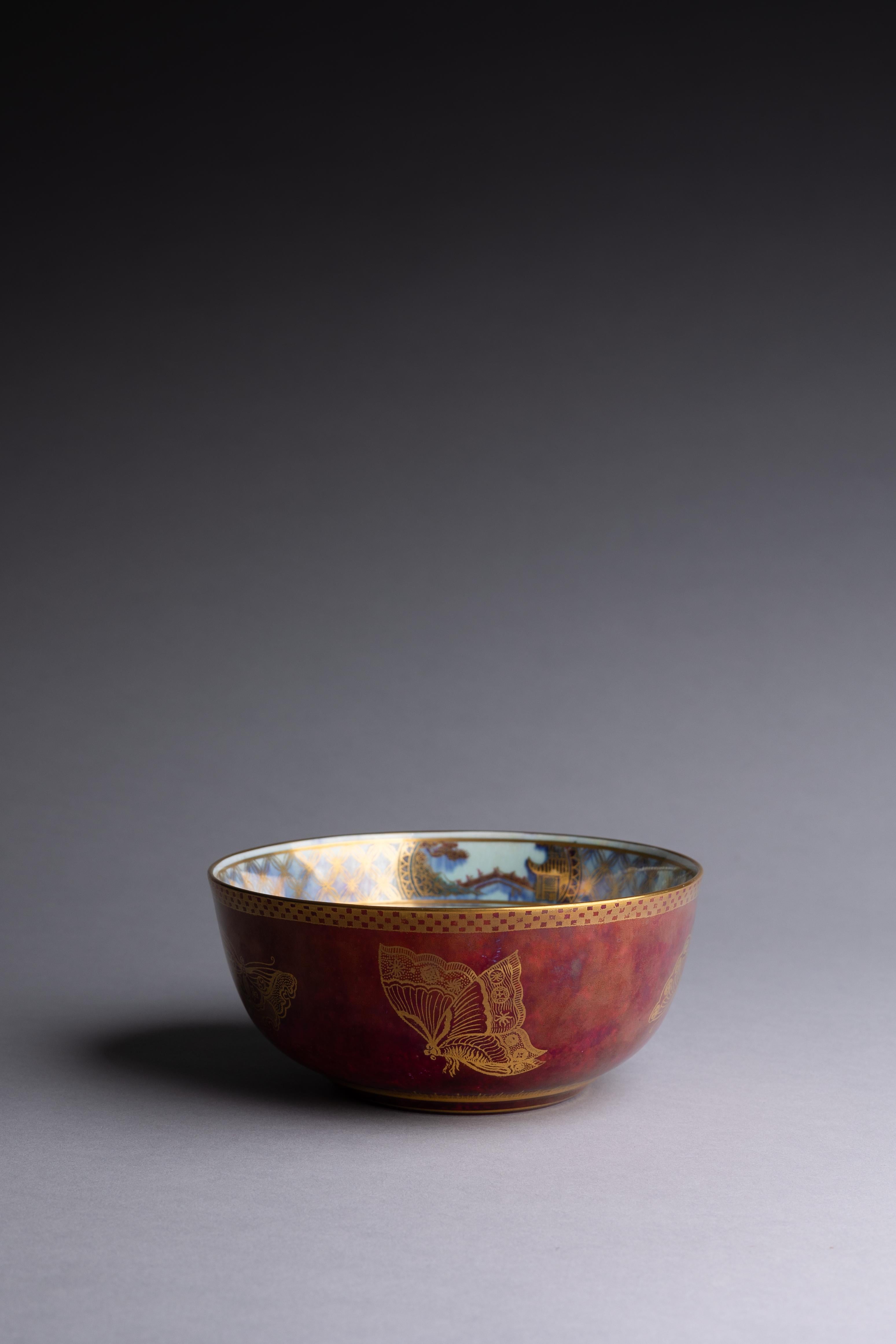 Un bol en rubis lustré de Wedgwood décoré de papillons dorés, conçu par Daisy Makeig-Jones vers 1915. 

Des papillons délicatement dorés décorent l'extérieur de ce bol sur une glaçure d'un profond lustre rubis. Ces motifs naturalistes sont accentués