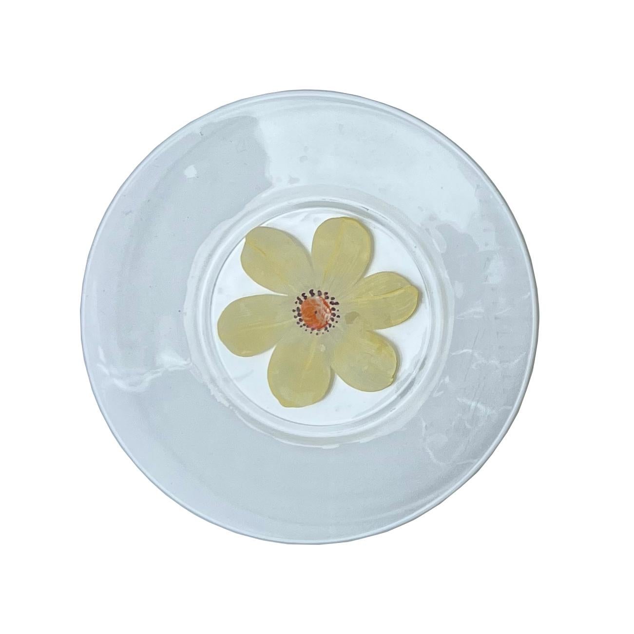 Delight your guests with the whimsical charm of these vintage hand-painted daisy plates. A delicate yellow daisy motif graces each of these small glass plates, adding a playful, enchanting touch to your table décor.

This set of four plates