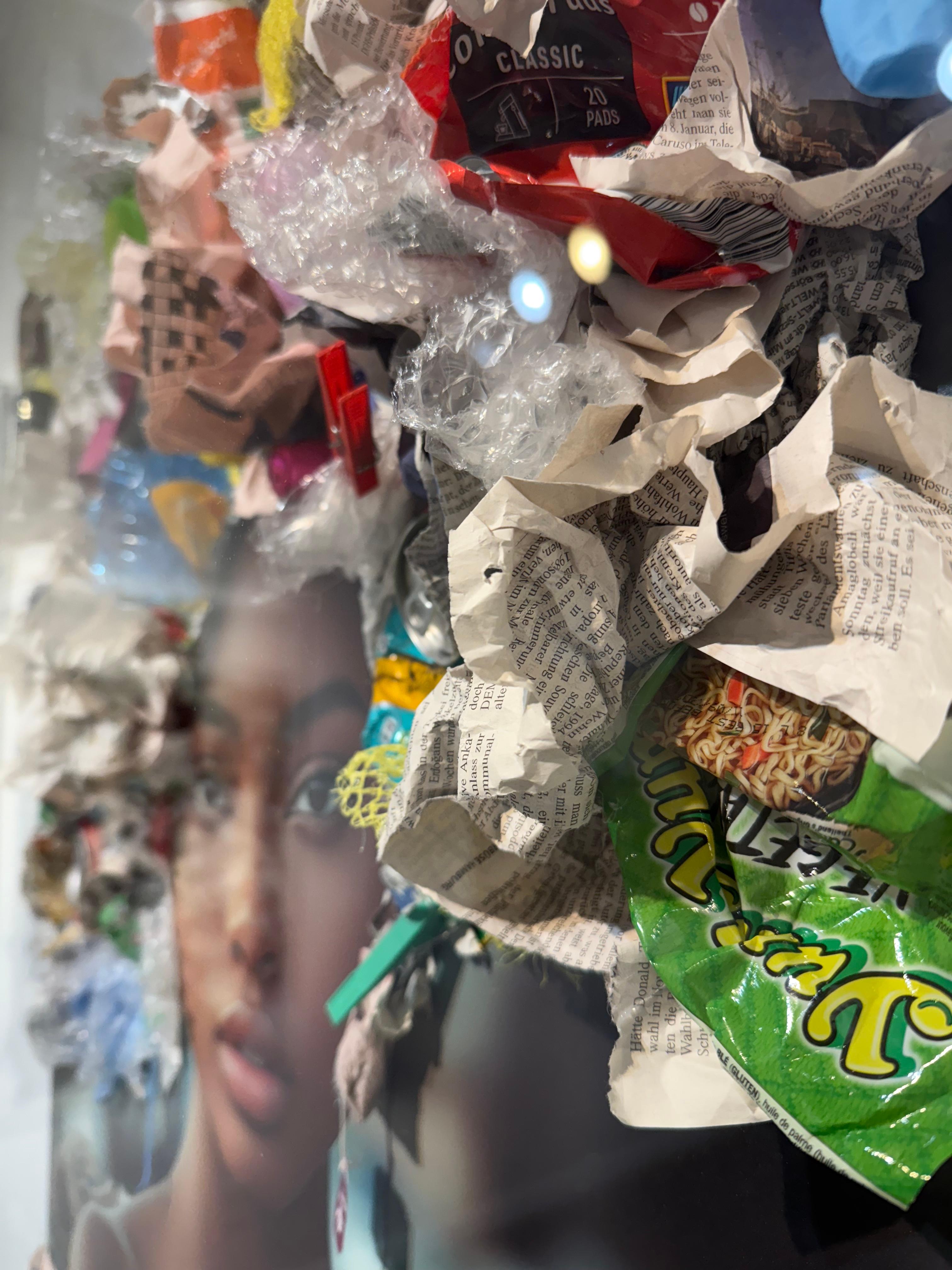 Garbage Queen est une série mixte saisissante qui mêle la photographie à des déchets physiques - plastiques jetés, journaux et autres débris récupérés - assemblés en vêtements sculpturaux et apposés à la surface de chaque tirage. Les images sont