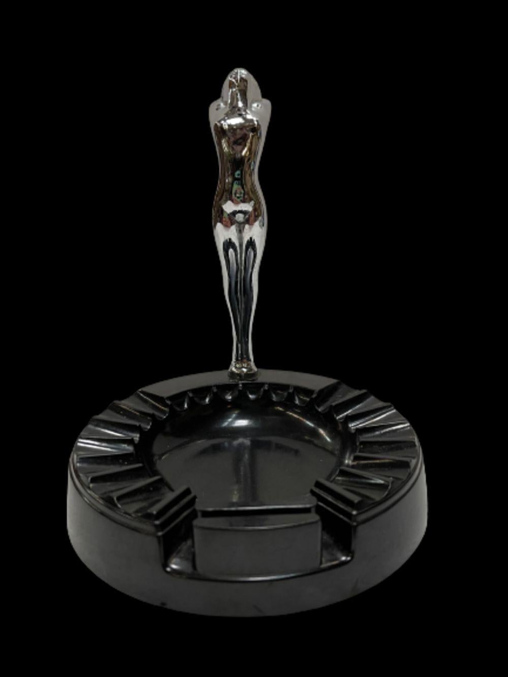 This Chicago-manufactured ashtray is a fine piece for the tobacco connoisseur. The tray is made from Bakelite and the goddess figure is chrome. The goddess is reminiscent of hood ornaments from classic cars of the 1930s, 1940s, and 1950s. She's