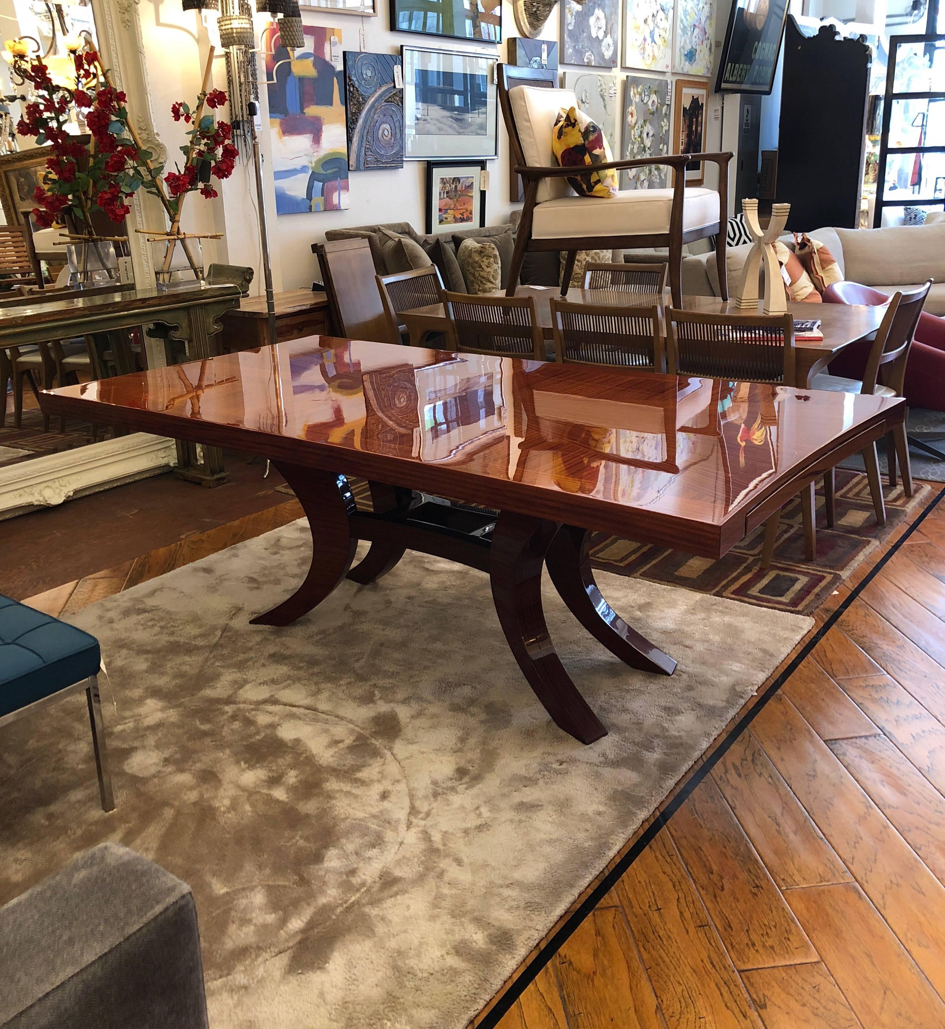 An exquisite Dakota Jackson Epoch series custom table. Table top is finish-ribbon mahogany in an elongated sunburst pattern. Carved pedestal base. Pullout mechanism at ends for leaves. Measure: 120
