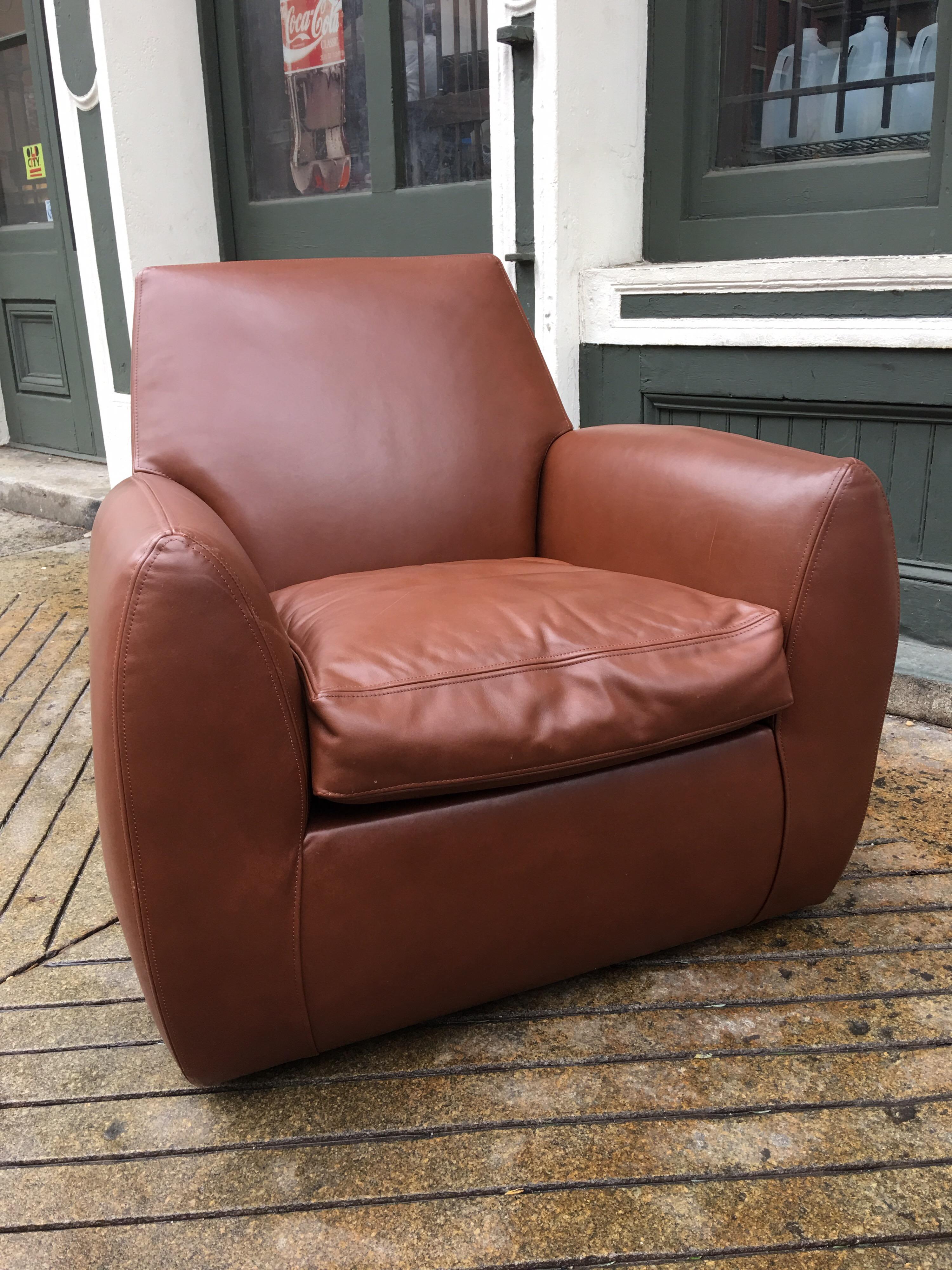 Dakota Jackson leather Ke-Zu club chair with matching ottoman. In beautiful condition with minimal wear. Beautifully designed stitching is a real stand out. Chair swivels and ottoman is on castors. Ottoman measures 23 x 24