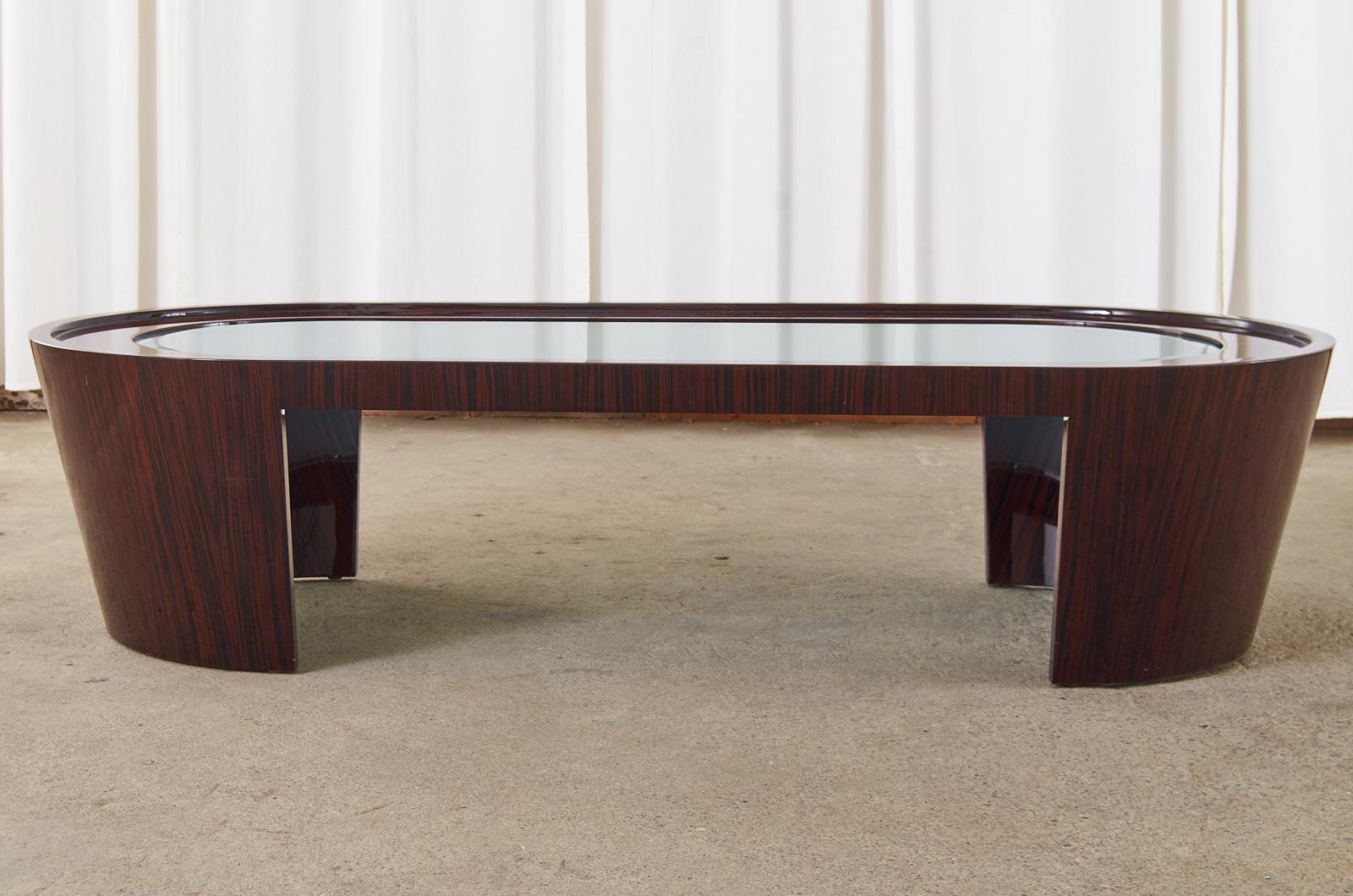 Fantastic cocktail table designed by Dakota Jackson. The grand cocktail coffee table features a wood frame encased in Macassar ebony veneer. The large table resembles a bathtub with dramatic flared sides and rounded ends. The top of the table is
