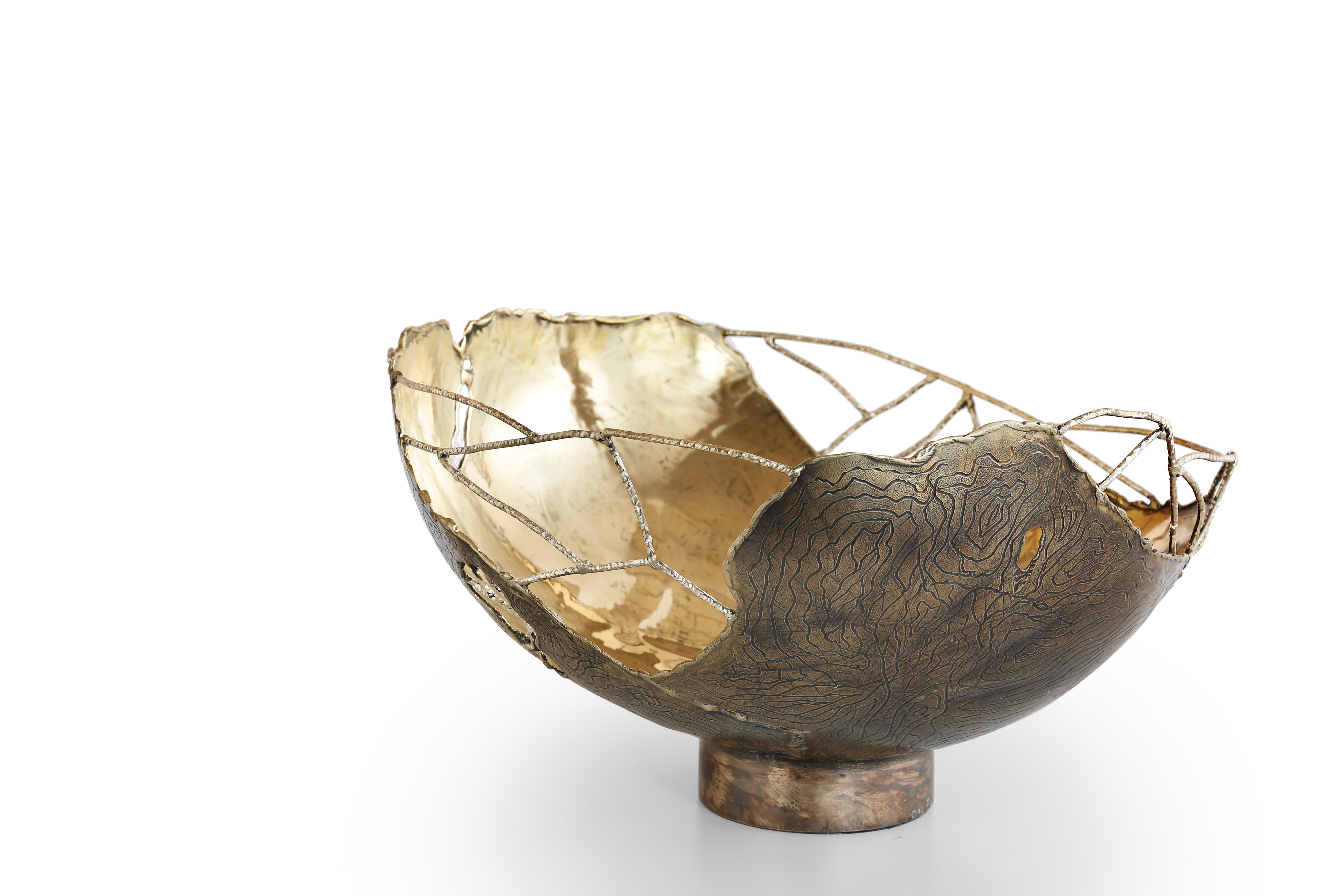 Cylindrical modern bowl in hammered brass molded with fire. Spider webs in welded brass wire. External surface carved with burnished and polished veins. Entirely handmade in Italy signed and numbered.

The power of fire, the connections between