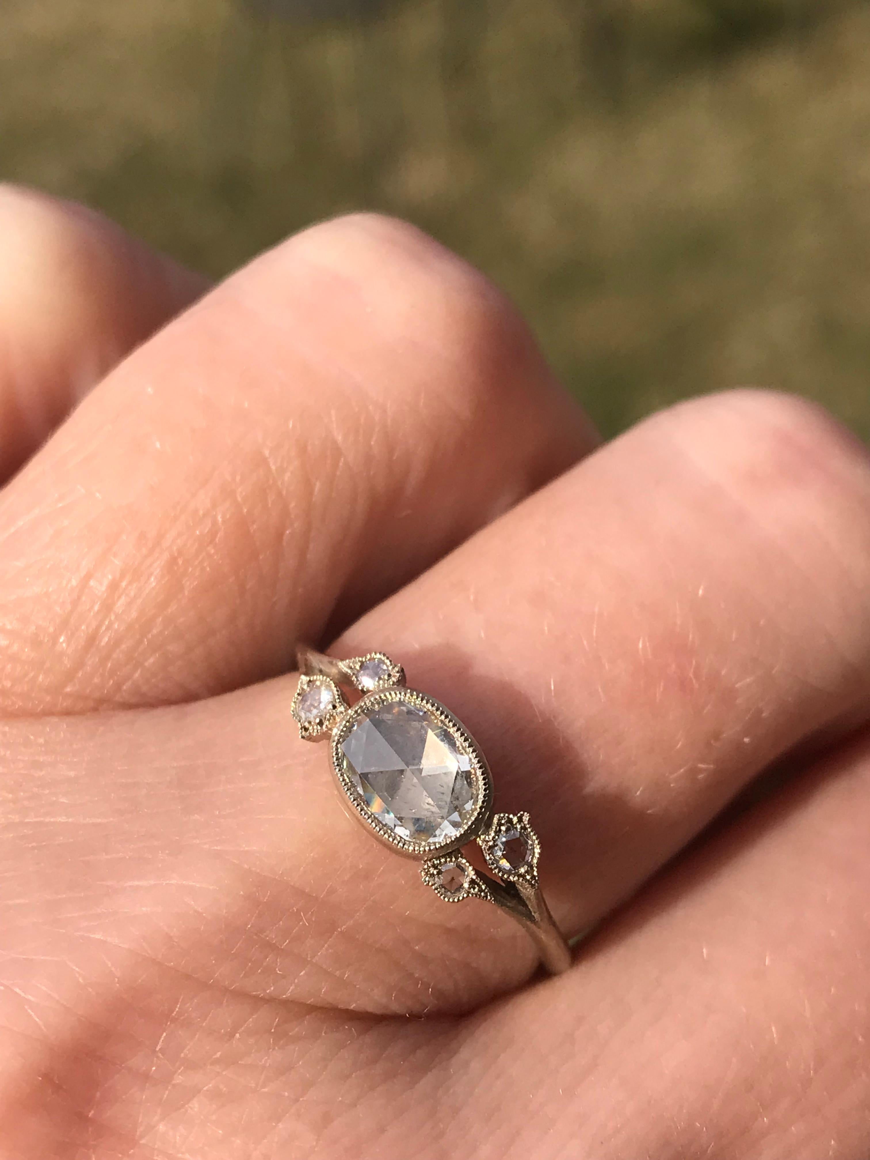 Dalben Design Oval Form Rosenschliff Diamant Ring montiert in 18 kt Weißgold, 
4 blumenförmige Milligrana, besetzt mit runden Diamanten im Rosenschliff auf beiden Seiten  gesamtgewicht 0,06 Karat . 
Ovaler Diamant im Rosenschliff, Gewicht 0,57