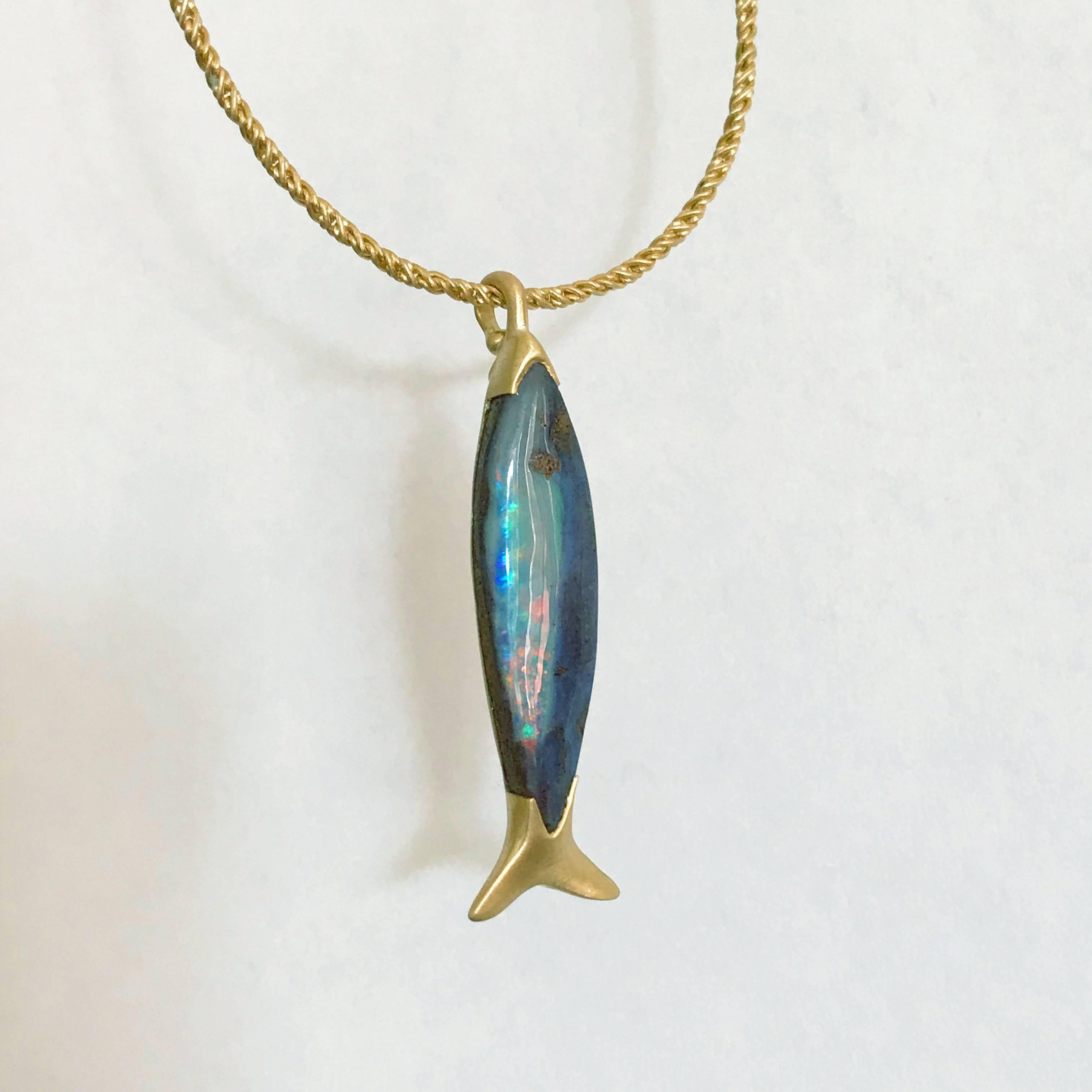 Dalben design 4,3 carat fish shape Australian Boulder Opal with a 18 kt cord style yellow gold pendant necklace.
The Australian Boulder Opal have a lovely fish shape witha little brown eye and multicolor spots on the belly.
It really looks like a